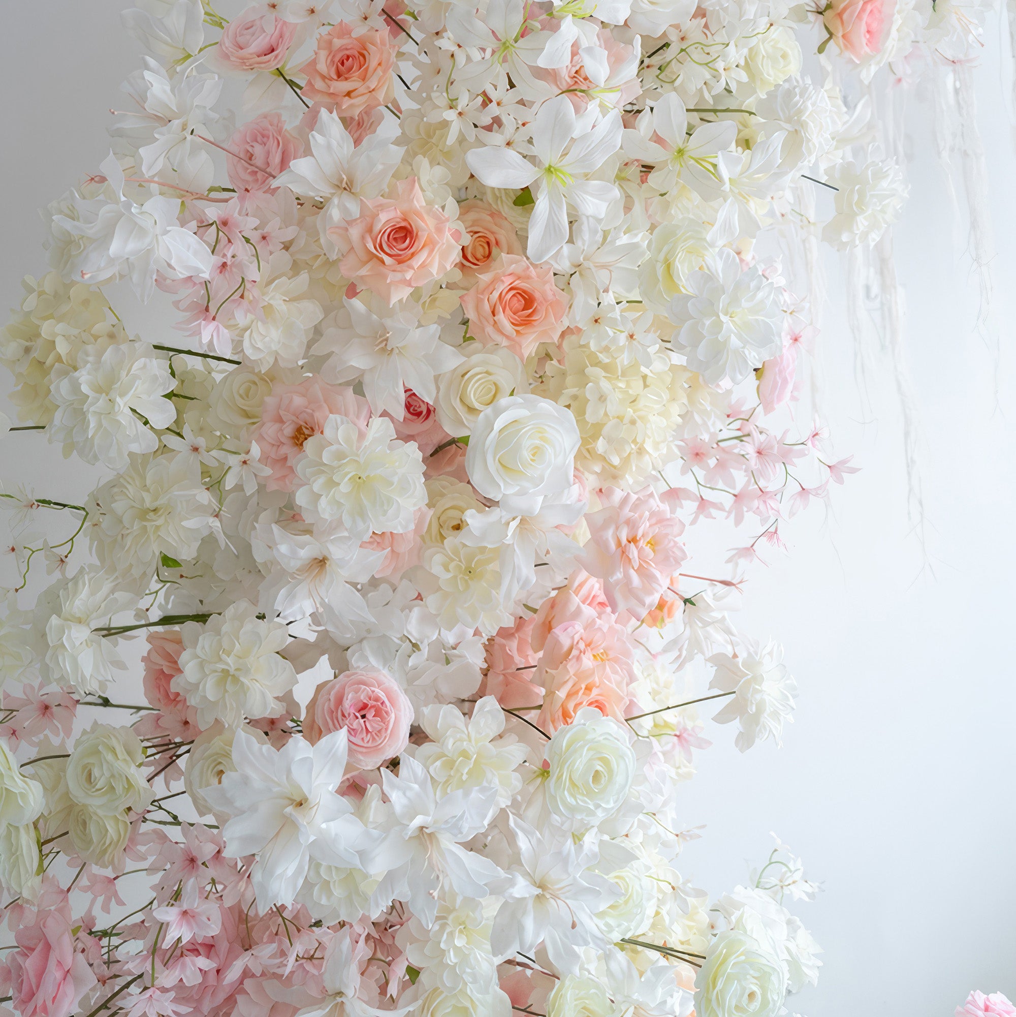 This image features an artificial flower arrangement with roses, hydrangeas, and other blooms in soft shades of white, light pink, and peach. The style is romantic and elegant, perfect for a wedding - themed setting.