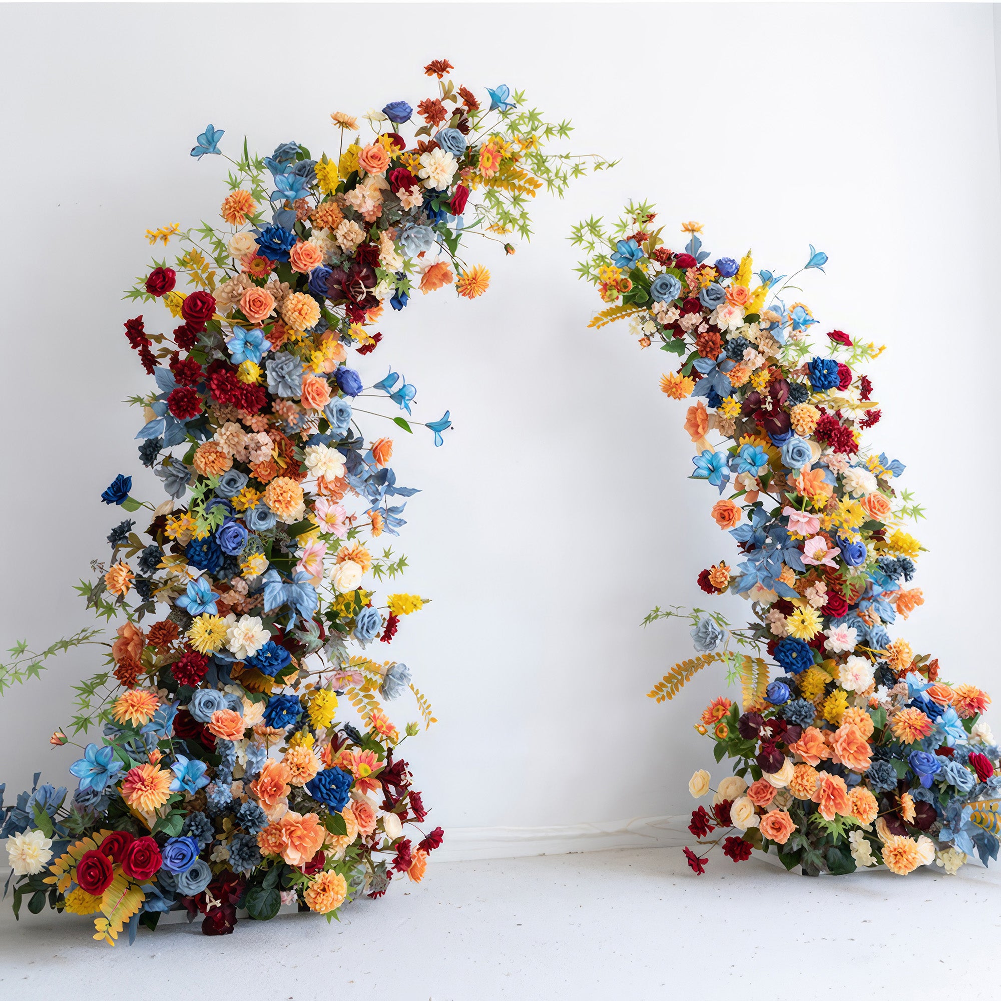 The image features a floral arch bursting with color, including vivid blues, warm oranges, deep reds, and soft pastels. It has roses, daisies, and other blooms. The style is bold, festive, and full of energy.