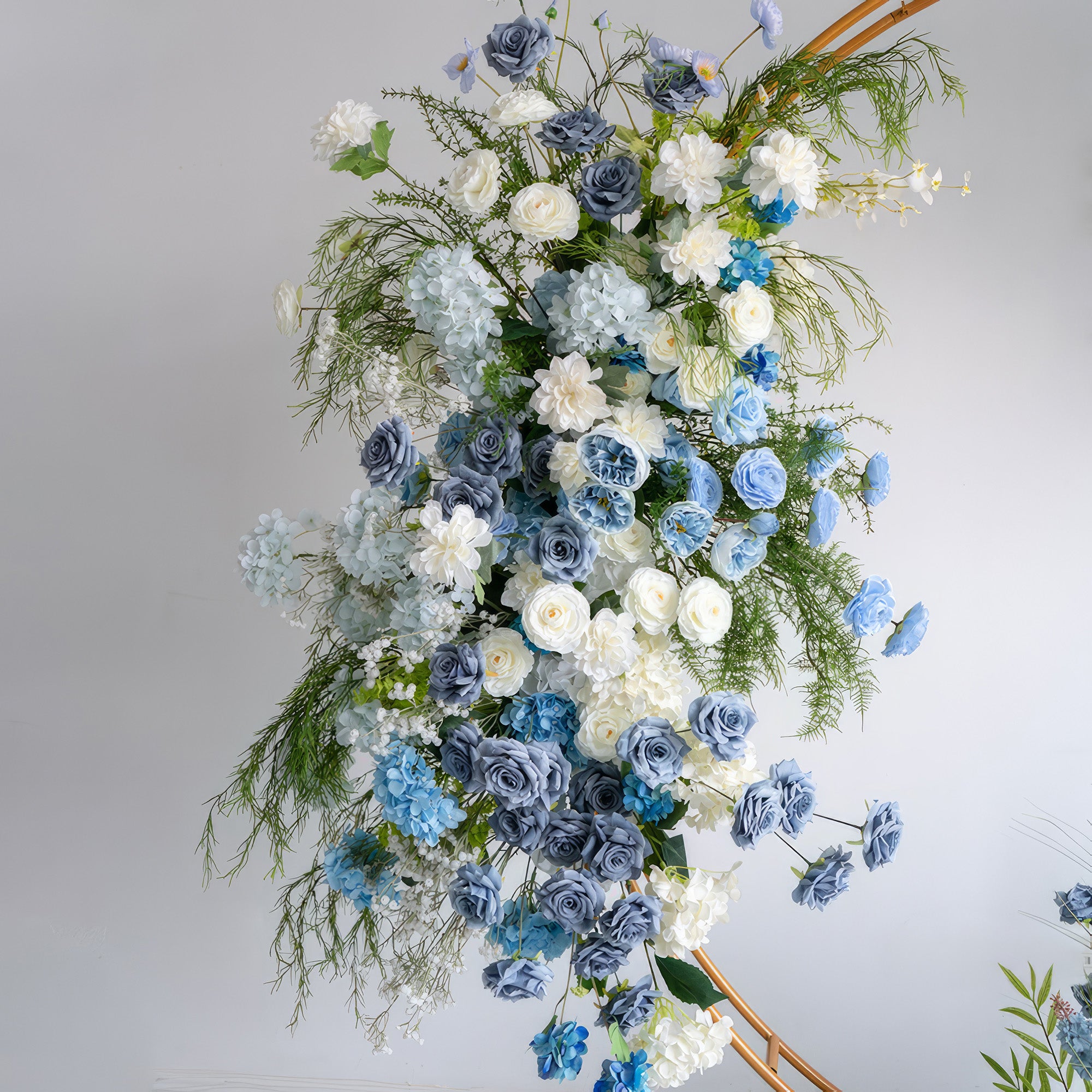 A cascading floral arrangement from Valar Flowers features a serene palette of sky blue, dusty blue, and creamy white blooms—including roses, hydrangeas, and delicate baby&