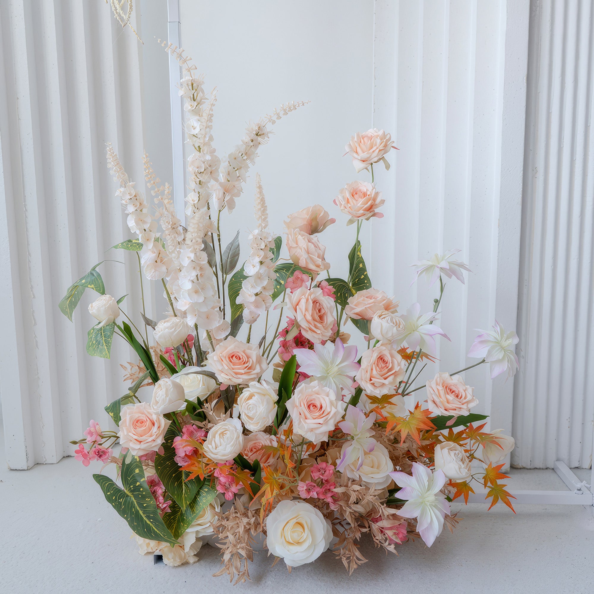 This image features an artificial flower arrangement with roses as the main type, along with other blooms. Colors include soft peach, white, and touches of pink and orange. The style is elegant and natural - looking.