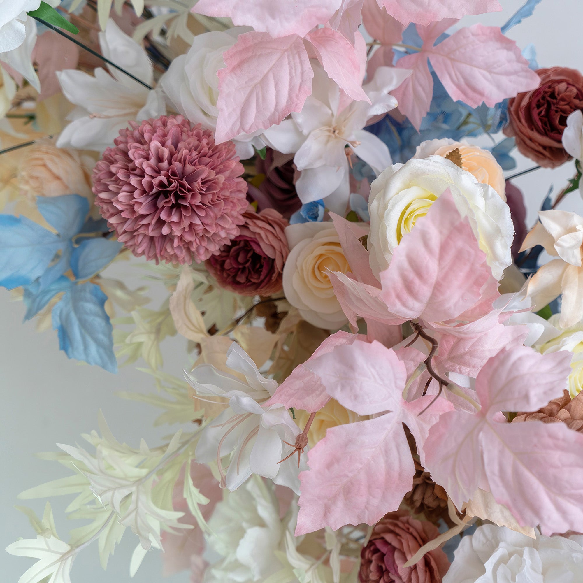 This floral cluster showcases a charming mix of colors—soft pinks, whites, blues, and hints of earthy brown. With roses, pom - pom flowers, and various leaves, it offers a delicate, romantic style. Ideal for wedding decor, party arrangements, or adding elegance to any space.