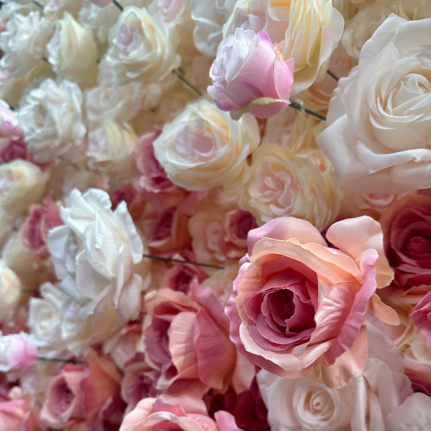 This image showcases a lush arrangement of artificial roses in various soft hues. The flowers range from creamy white to delicate pink and peachy - orange tones, creating a harmonious and gentle color palette. The roses are densely packed, exuding a romantic and elegant style, perfect for event decorations, such as weddings or photo - backdrops.
