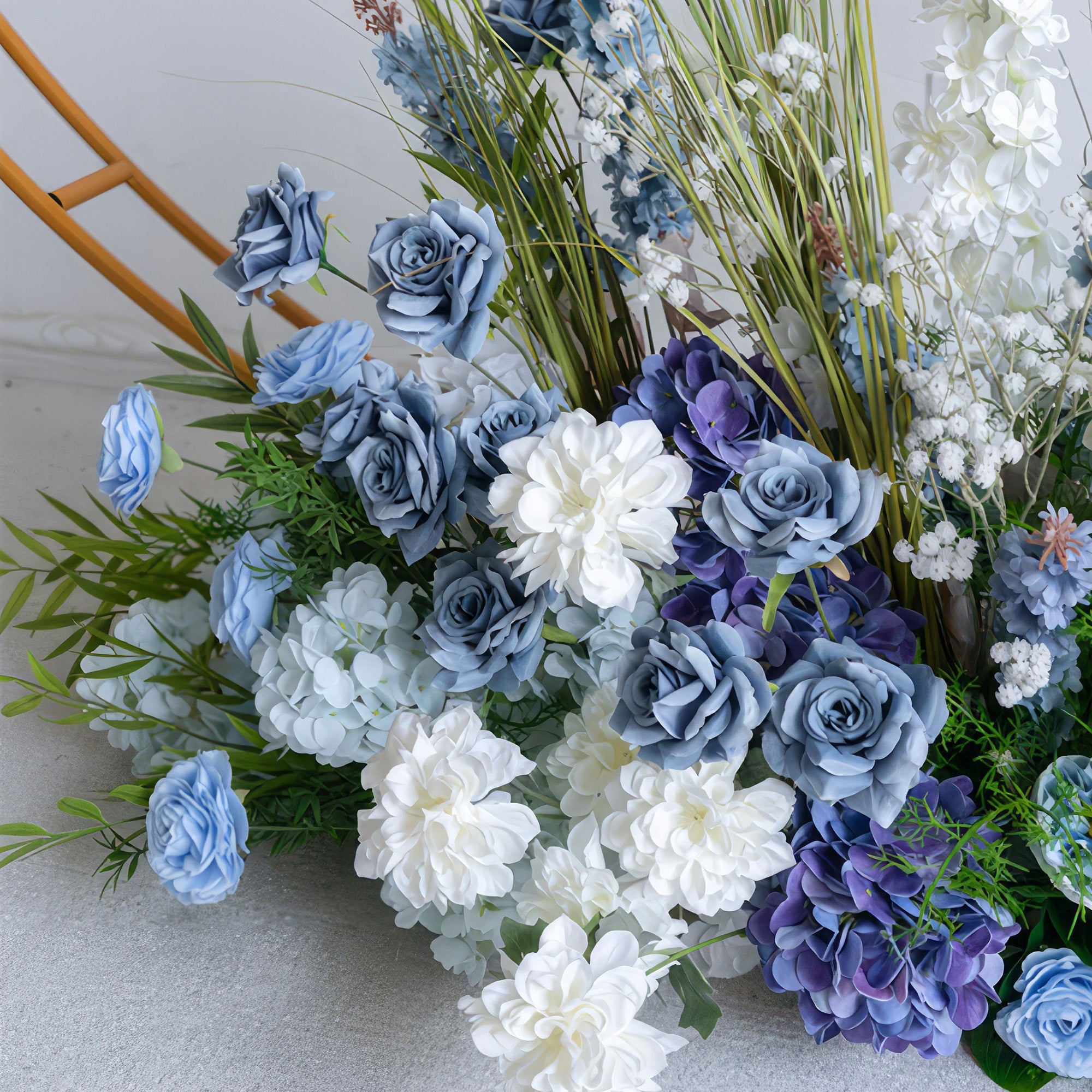 A close-up of a lush floral arrangement from Valar Flowers, featuring a harmonious blend of deep navy, sky blue, and creamy white blooms—including roses, hydrangeas, and delicate baby&
