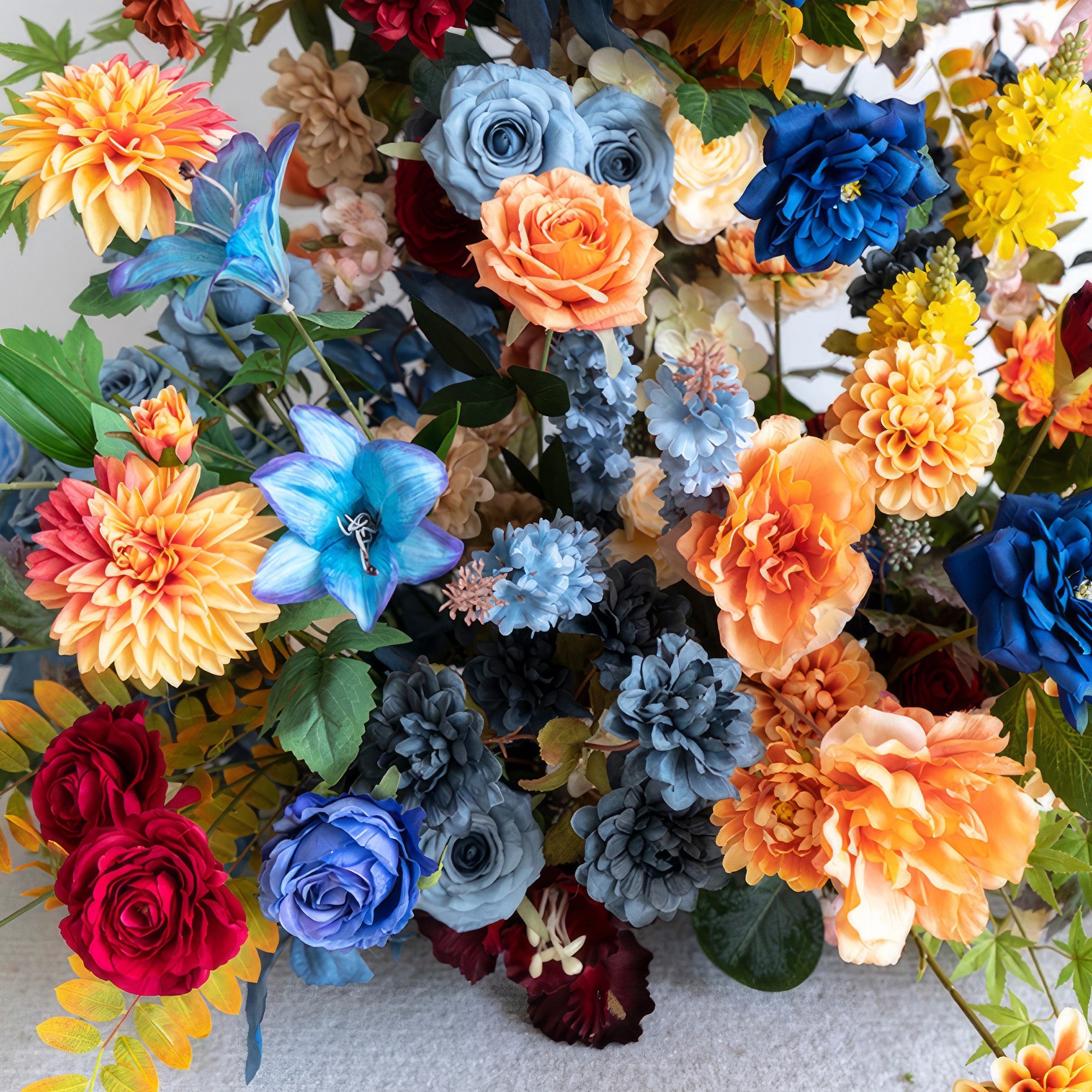 This image features a vibrant mix of artificial flowers. Colors span from deep red and blue to bright orange and yellow. Styles include roses and dahlias. The overall style is lively and eye - catching, perfect for a festive setting.