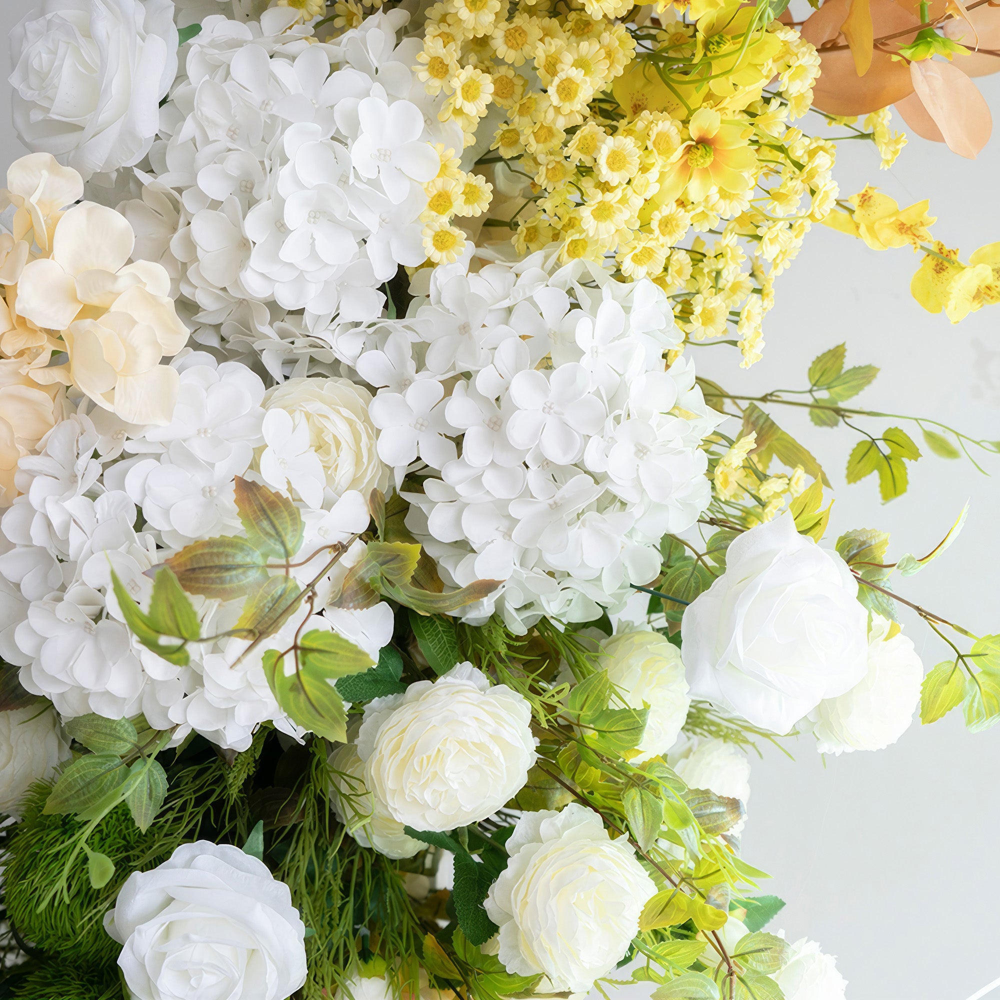 This image displays an artificial flower arrangement with a color scheme of pure white, soft cream, and bright yellow. It includes white roses, hydrangeas, and small yellow blooms. The style is fresh and elegant, exuding a sense of purity.