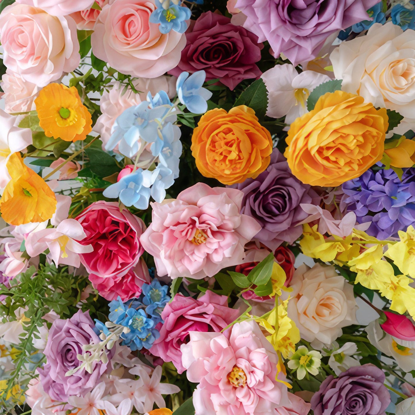 This image showcases a richly colorful assembly of artificial flowers. There are roses in pastel pinks, deep purples, and bright oranges. Alongside them are blue hydrangea - like blooms and small yellow flowers. The overall effect is lively and festive, exuding a joyful, celebratory style.