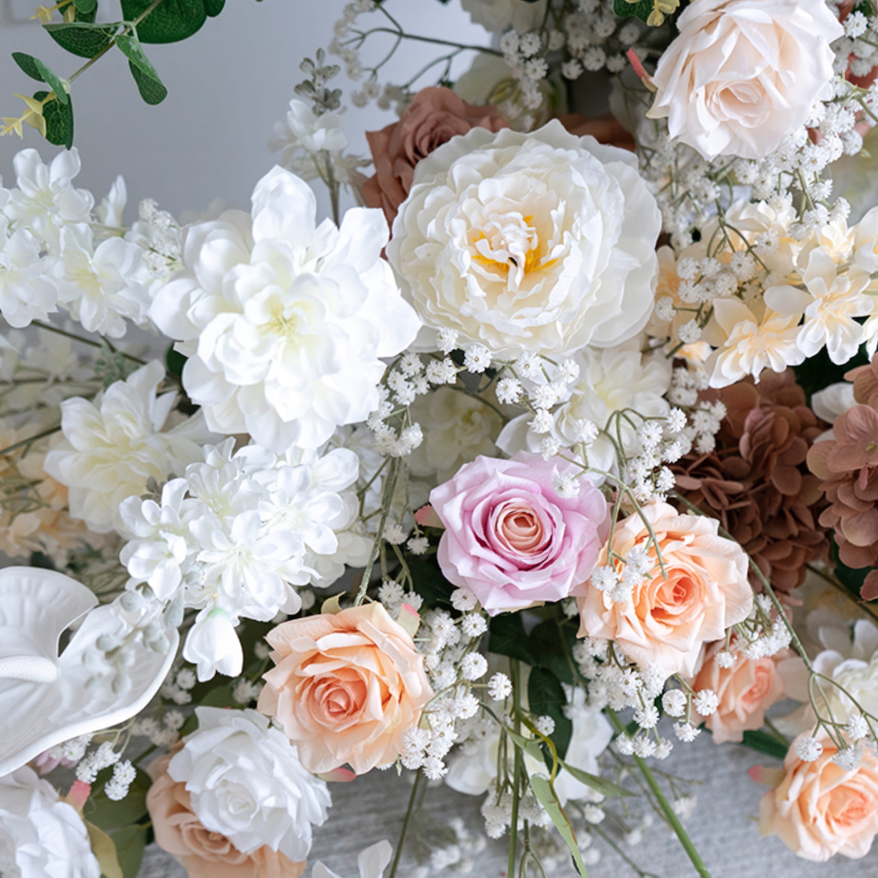 A close-up of a lush floral arrangement from Valar Flowers, featuring a harmonious blend of blush pink, terracotta, creamy white, and ivory blooms—including roses, peonies, and delicate baby&