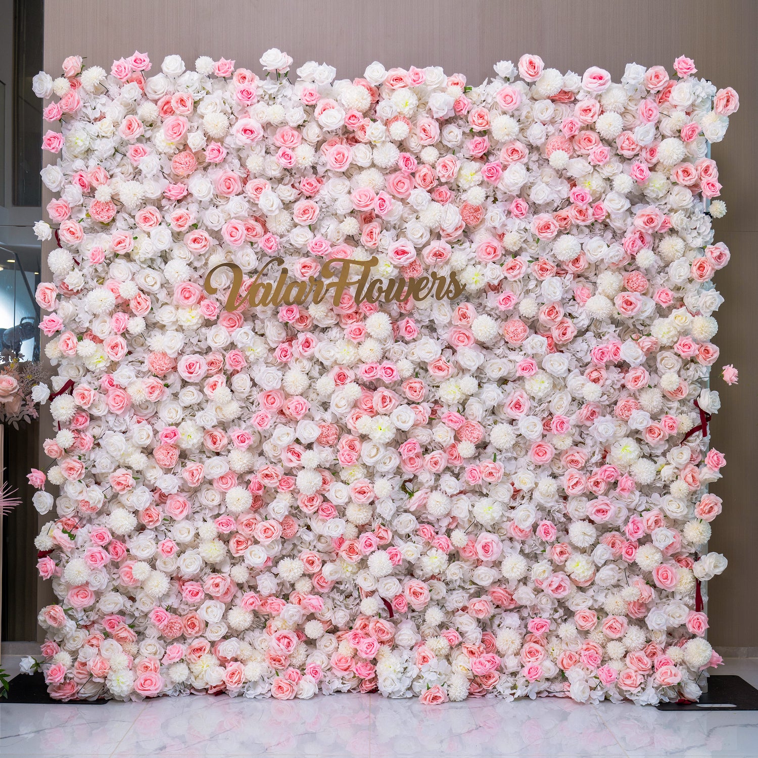 This image shows a beautiful floral wall with a mix of pink and white flowers. The wall is labeled "Valar Flowers," making it a perfect backdrop for wedding decorations.