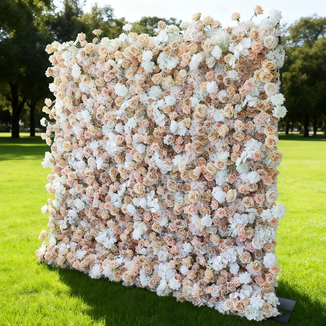 This image features a large, square floral wall outdoors on a lush green lawn. It&