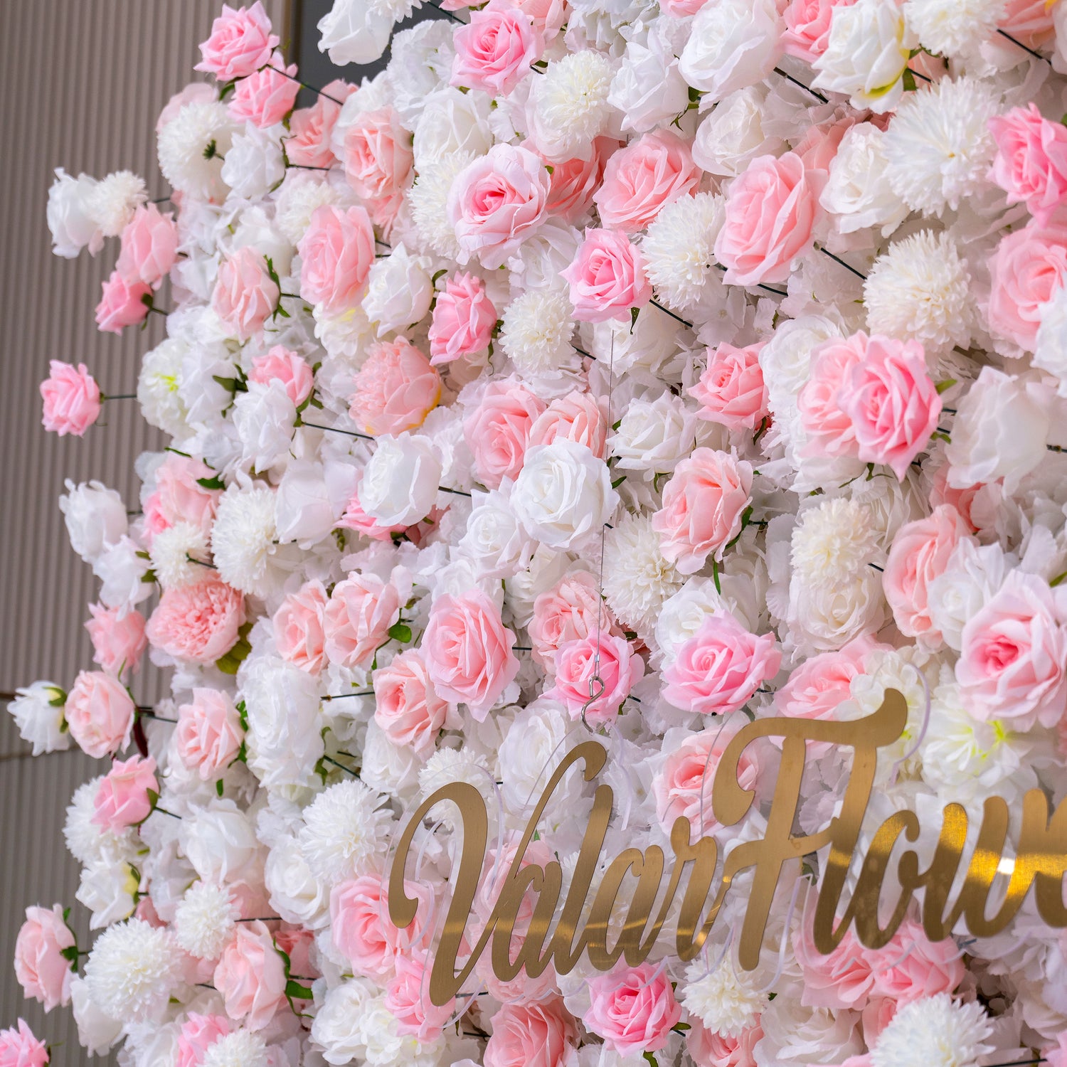 The image shows a beautiful floral wall with pink and white flowers. The text "Valar Flowers" is prominently displayed in the center. This setup is ideal for weddings or events as a decorative backdrop.