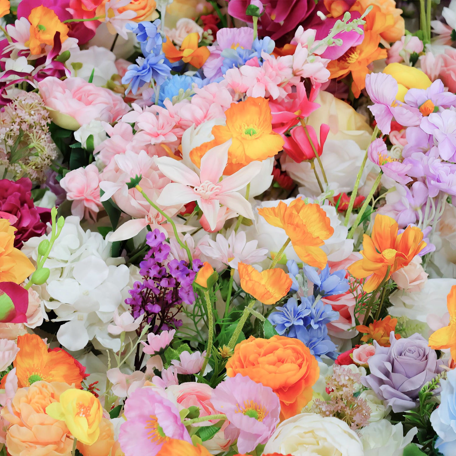 This image showcases a vibrant and densely packed arrangement of artificial flowers. The color palette is a vivid mix of soft pastels like pink, lavender, and light blue, along with bold hues such as bright orange, yellow, and red. Flower types include roses, lilies, daisies, and other assorted blooms. The overall style is exuberant and cheerful, creating a lively and eye - catching display.