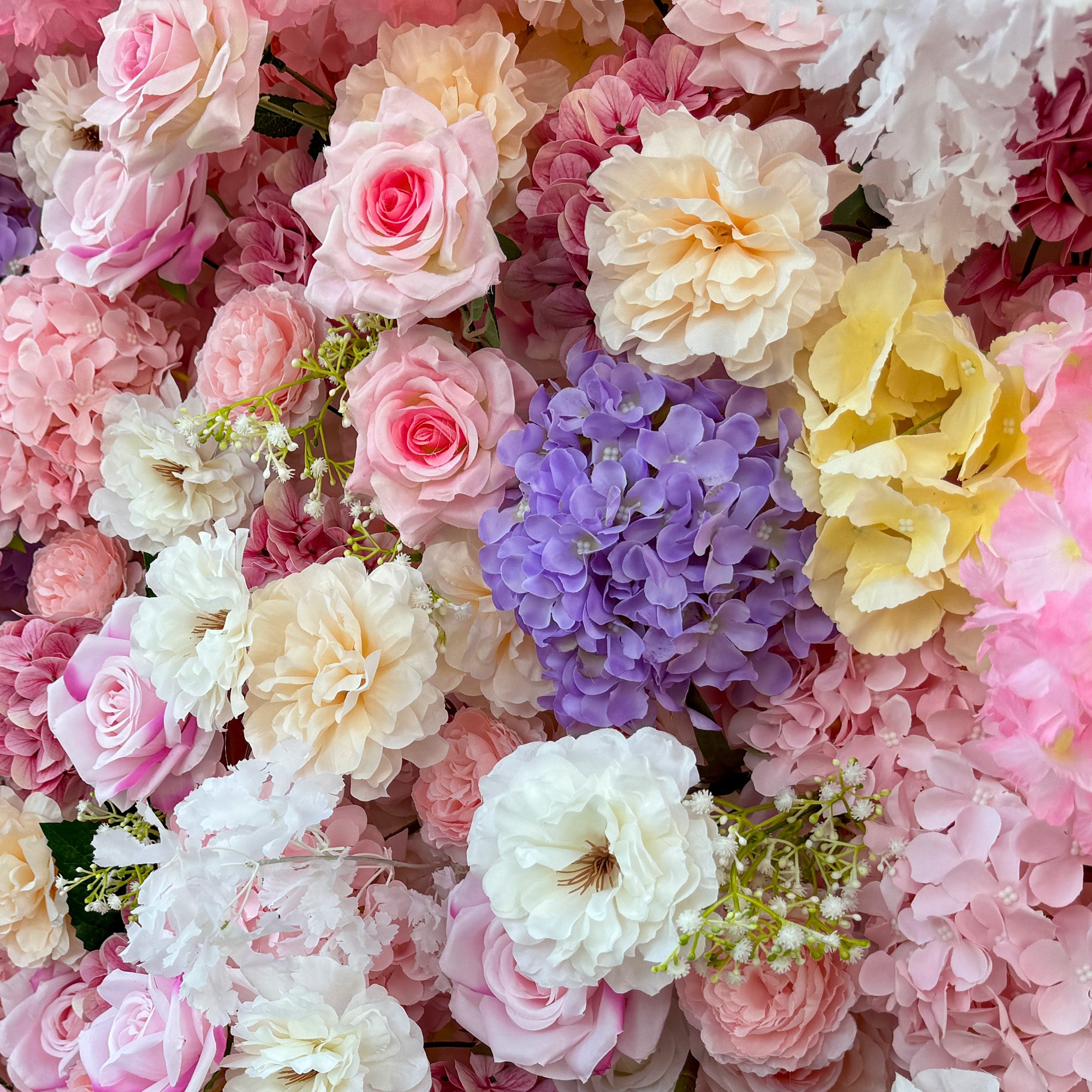 This photo from ValarFlowers showcases a lush floral arrangement. It features roses in soft pink, white, and peach hues, hydrangeas in purple, along with delicate white flowers and small green - stemmed blooms. Ideal for weddings, bridal showers, or romantic events, this dreamy and colorful mix exudes charm and elegance, creating a visually stunning backdrop.