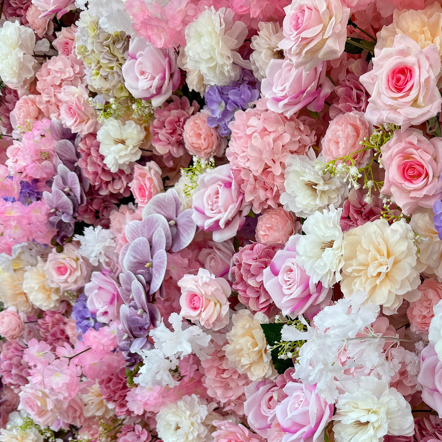 This photo from ValarFlowers showcases a lush floral arrangement. It features roses in soft pink, white, and peach hues, hydrangeas in shades of purple and pink, and delicate white flowers with small green - stemmed blooms. Purple orchids add an elegant touch. Ideal for weddings, bridal showers, or romantic events, this dreamy mix exudes charm and sophistication, creating a visually stunning backdrop.