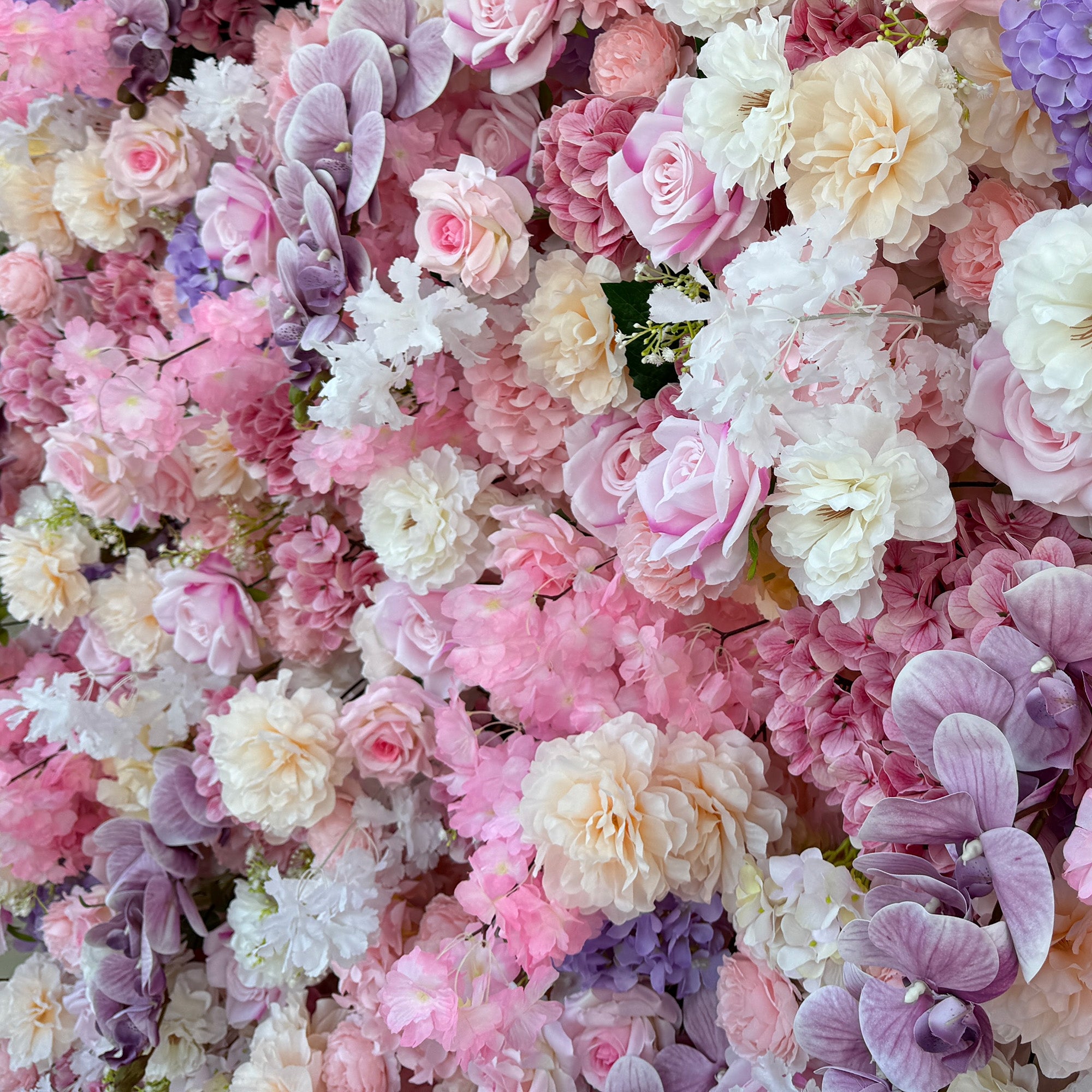 This photo from ValarFlowers showcases a lush floral arrangement. It features roses in soft pink, white, and peach tones, hydrangeas in shades of purple and pink, and delicate white flowers with small green - stemmed blooms. Purple orchids add an elegant touch. Ideal for weddings, bridal showers, or romantic events, this dreamy and colorful mix exudes charm and sophistication.