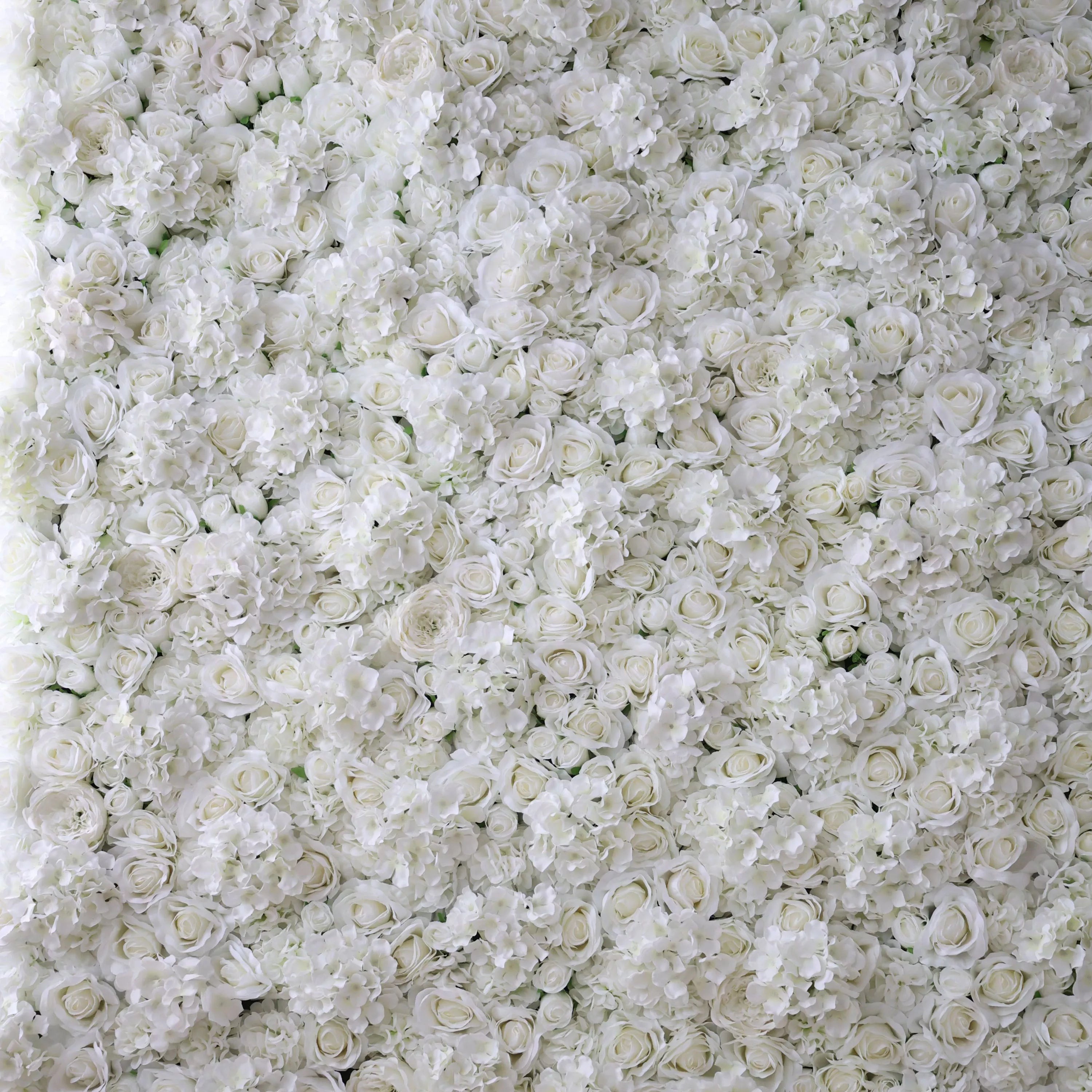 This is a close-up of a lush, all-white artificial flower wall from **Valar Flowers**, densely packed with a rich mix of white roses, hydrangeas, and delicate filler blooms. The tightly packed, layered display creates a clean, elegant, and dreamy aesthetic, ideal for wedding backdrops, photo shoots, or special event decor.