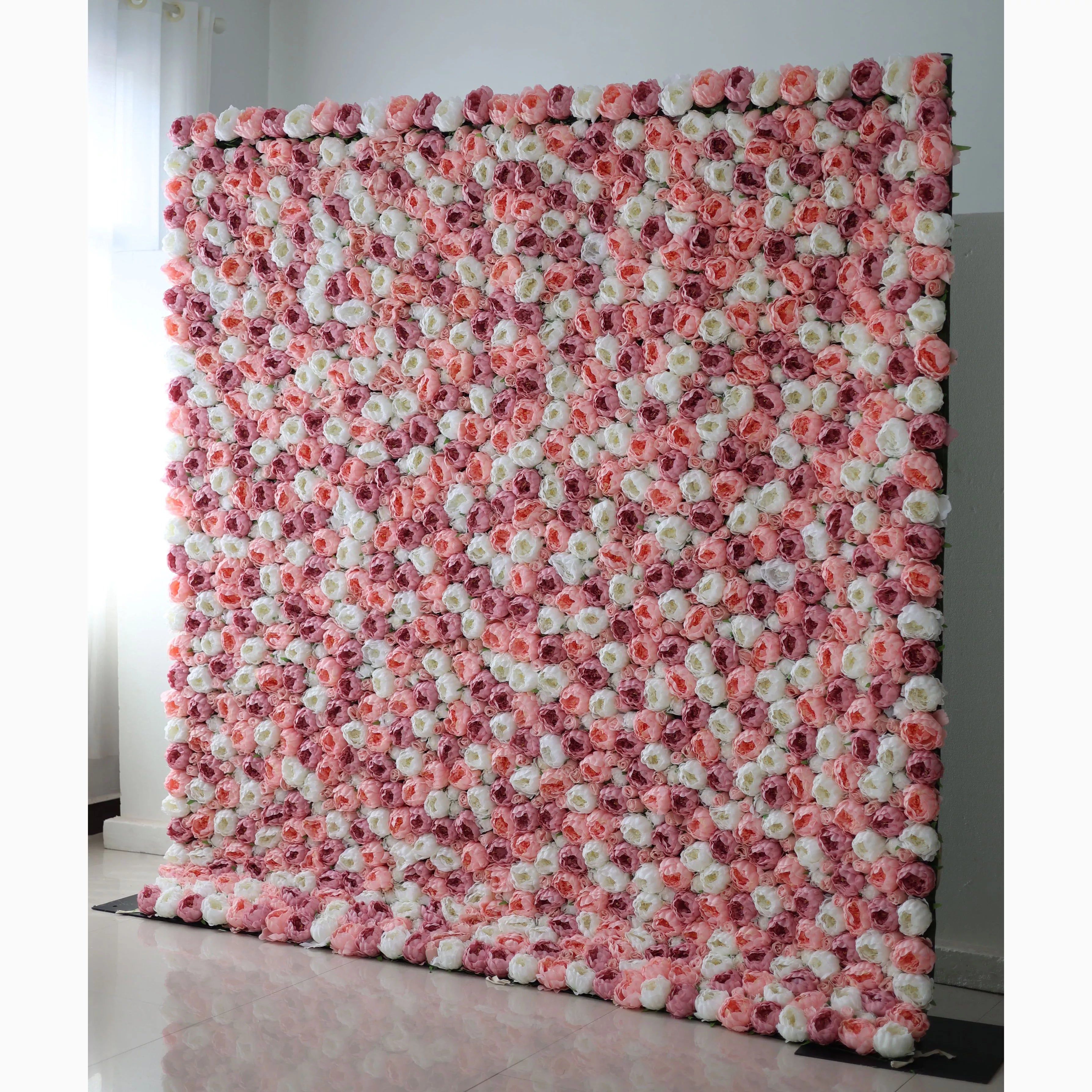 A large artificial flower wall displays a stunning pattern of pink, white, and light pink roses. The blooms are densely packed, creating a lush, textured, and visually striking backdrop. The harmonious color blend gives off a romantic, elegant vibe, perfect for adding a decorative touch to events or spaces.
