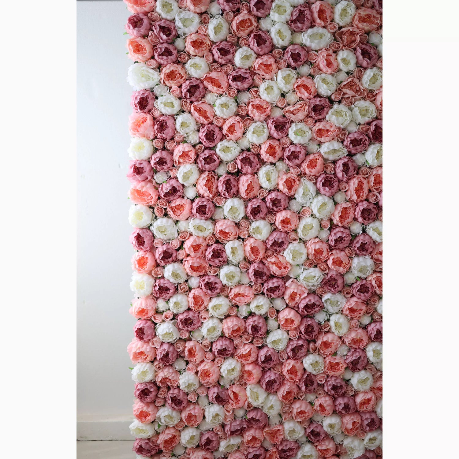A vertical artificial flower wall showcases a beautiful arrangement of roses in soft pink, white, and deeper pink tones. The blooms are densely packed, creating a lush, textured, and romantic backdrop. Perfect for adding an elegant, dreamy touch to events or decor.