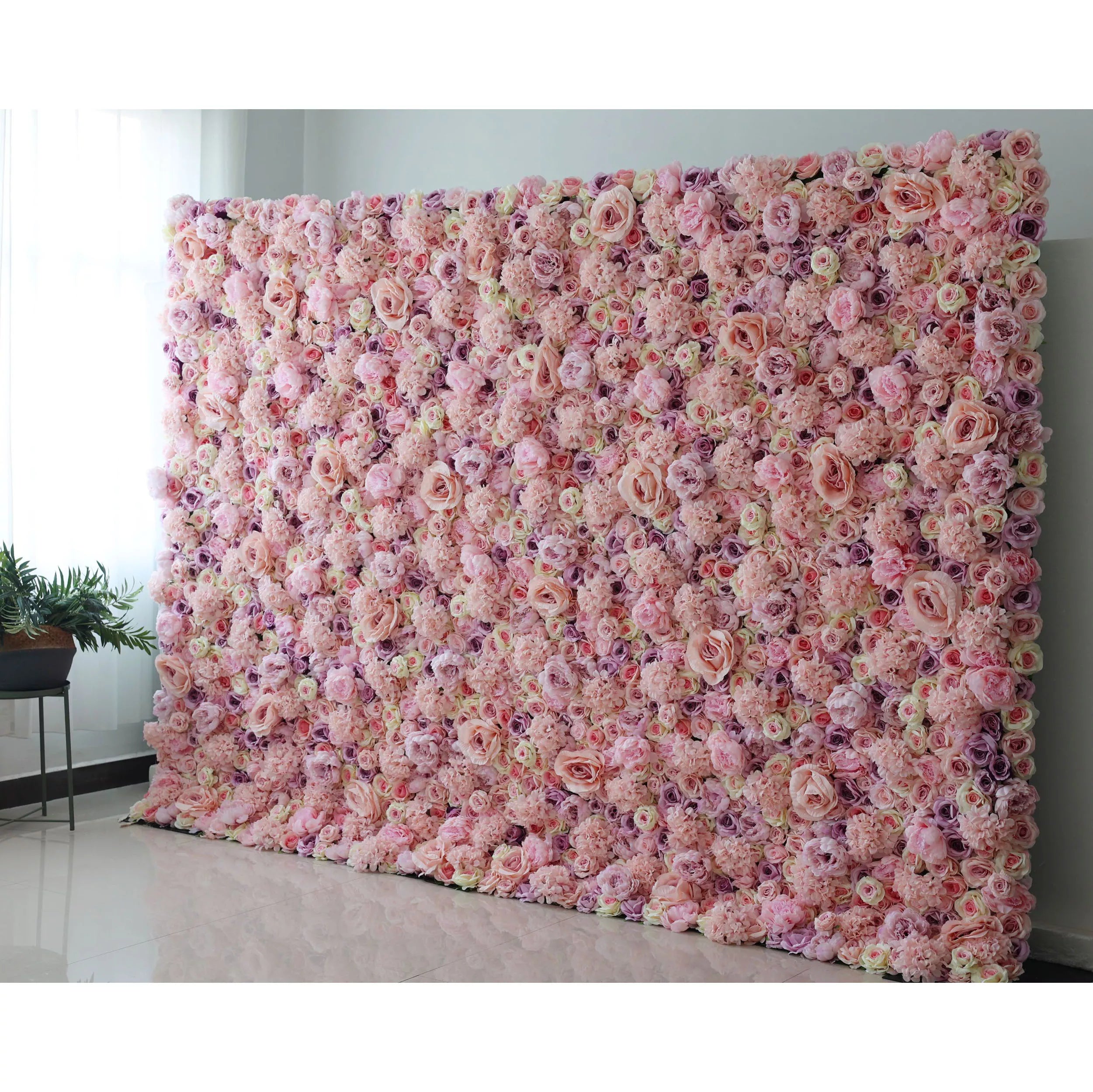A large floral fabric wall with a pink, red, purple, and yellow color scheme, arranged as a backdrop or decoration in a room.