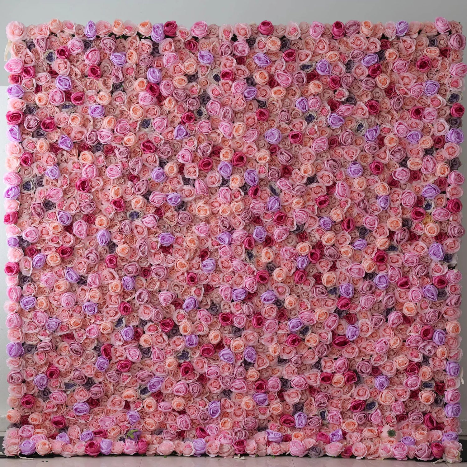 This large artificial flower wall features a dense arrangement of roses in soft pink, peach, purple, and red. The harmonious color blend creates a lush, romantic texture, exuding elegance. Perfect as an event backdrop, it brings a dreamy, charming atmosphere with its intricate floral design.