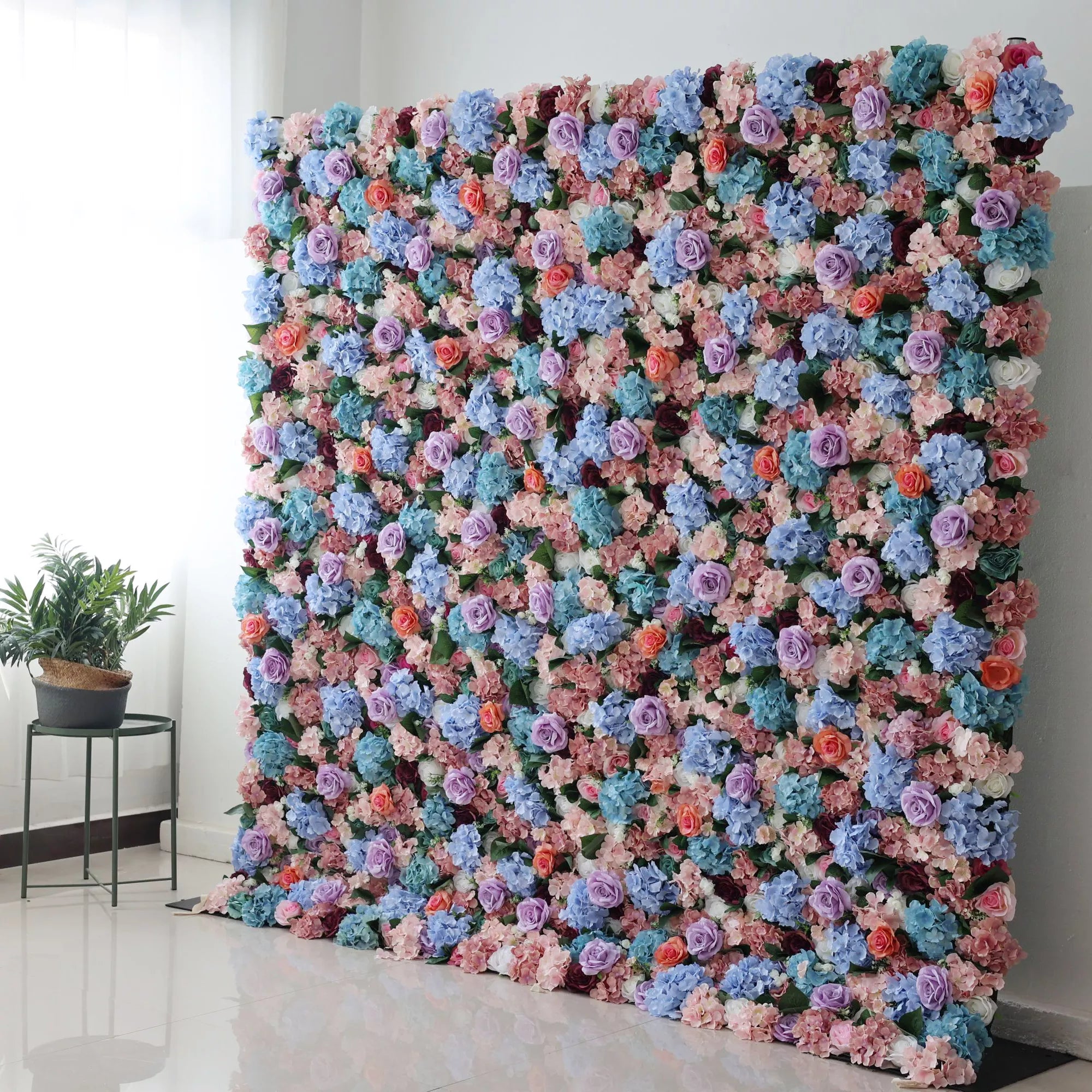 This large artificial flower wall bursts with colors—blue hydrangeas, purple roses, peach blooms, and greenery. Densely packed, it creates a lush, vibrant display. Perfect for events, it brings a cheerful, romantic vibe, adding an eye - catching, decorative charm to the space.