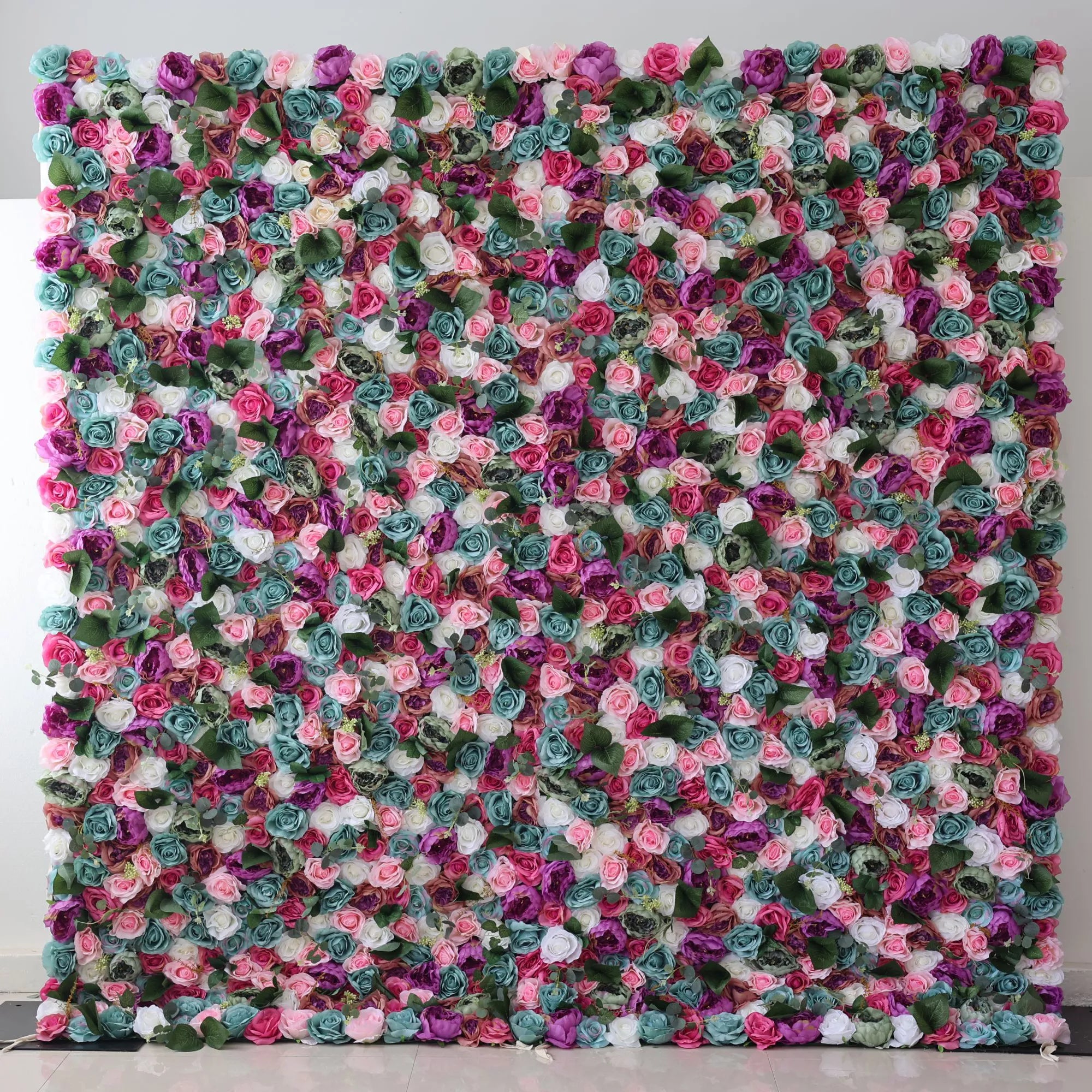Valar Flowers Presents: This large artificial flower wall is a vibrant tapestry of colors. It features an array of roses in shades of pink, purple, white, teal, and more, interspersed with green foliage. The dense, intricate arrangement creates a lush, eye - catching display, perfect for adding a romantic, decorative touch to events or spaces.