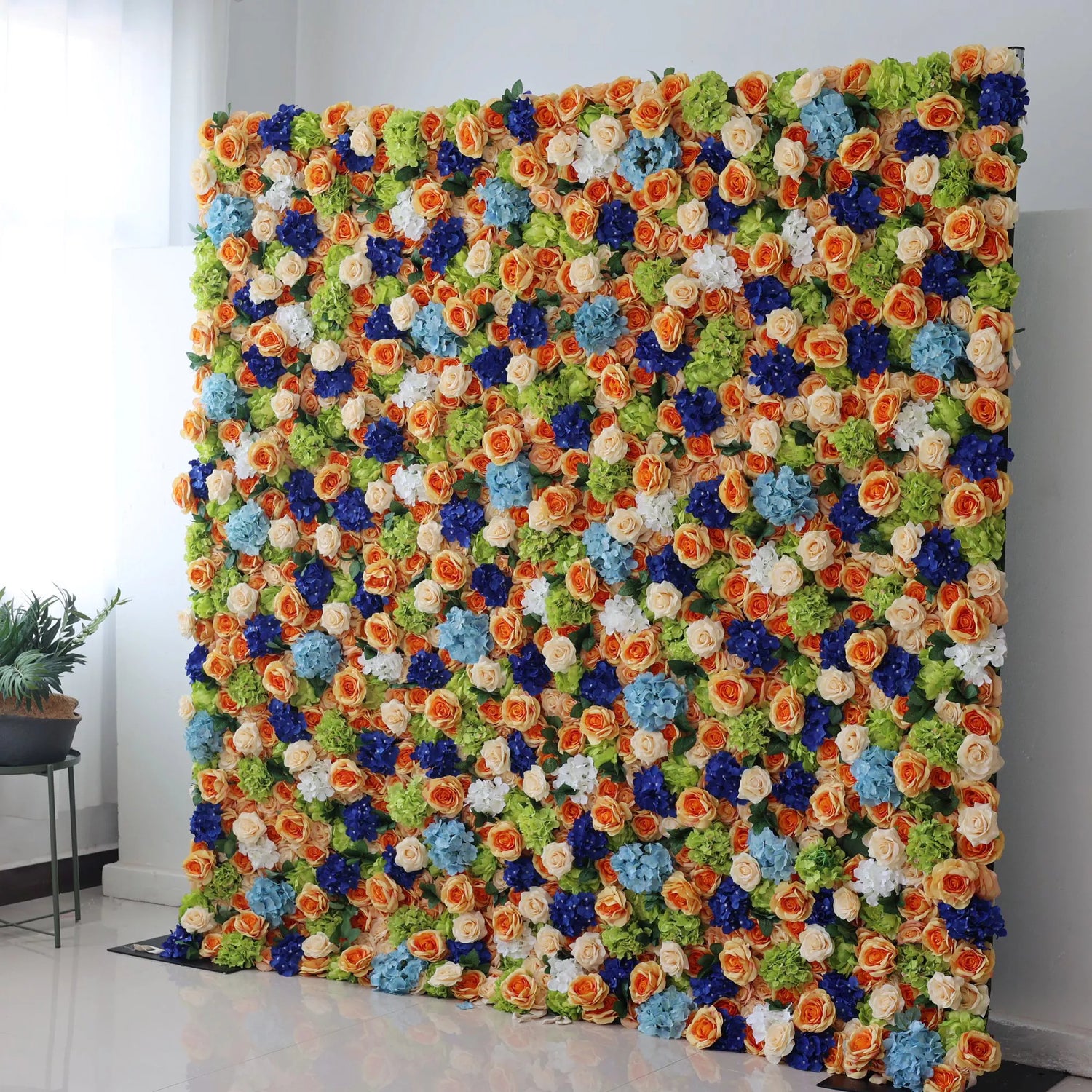 Valar Flowers Roll Up Backdrop: This large artificial flower wall is a vibrant, colorful display. It features a mix of orange roses, blue blossoms, white flowers, and green foliage, densely arranged to create a lush, textured look. The harmonious blend of colors evokes a cheerful, lively atmosphere, making it perfect as a backdrop for events like weddings, parties, or photo shoots, adding an eye - catching and decorative touch.