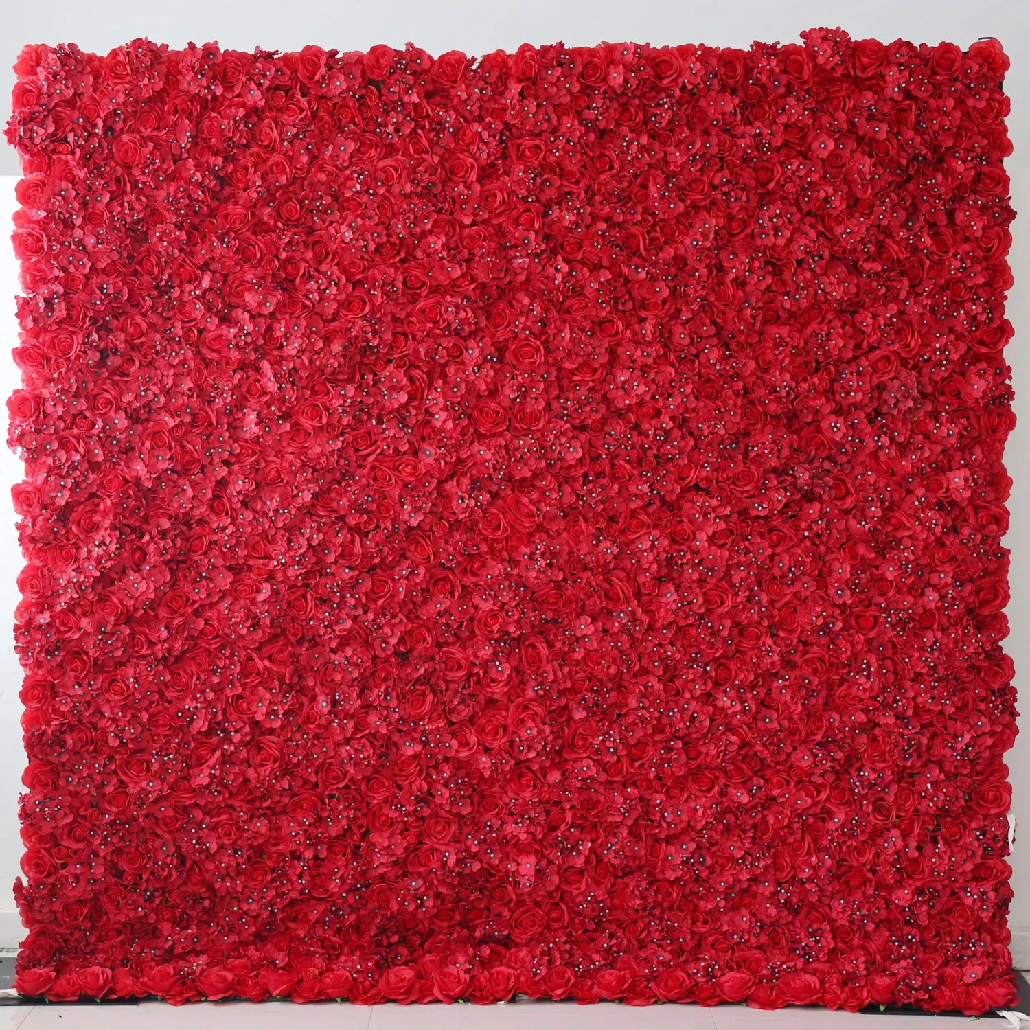 Valar Flowers Roll Up Artificial Flower Wall Backdrop: This is a large artificial flower wall, densely covered with vibrant red roses. The uniform, lush arrangement creates a bold, passionate, and elegant visual. It serves as a striking backdrop, ideal for adding drama and romance to events like weddings, photo shoots, or special celebrations, enhancing the atmosphere with its rich color.