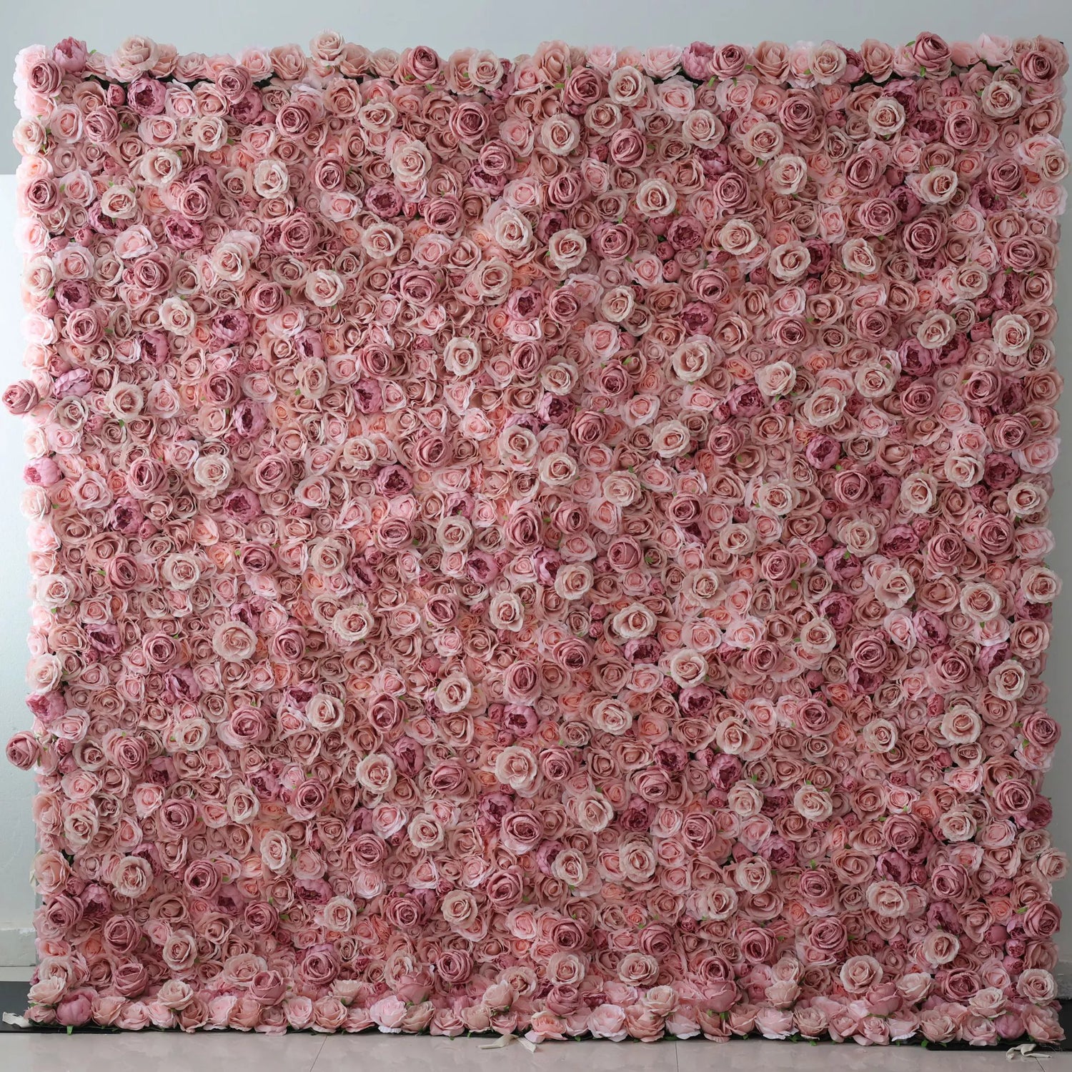 A massive artificial flower wall, densely packed with soft pink roses in varying shades. The uniform, delicate blooms create a romantic, dreamy backdrop, perfect for adding an elegant, sweet touch to events or decor.