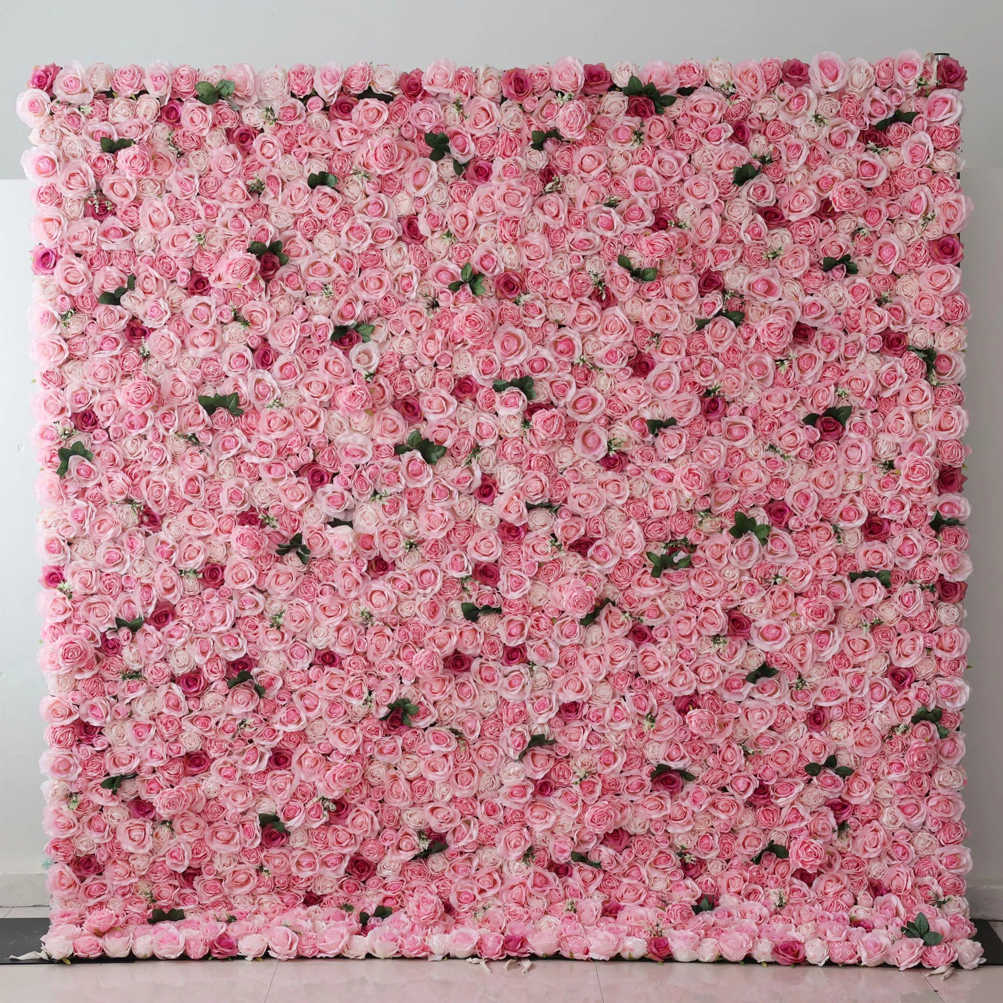 This is a large artificial flower wall covered with dense, soft - pink roses. Among them, there are some darker - colored rose buds scattered, adding a touch of contrast. The uniform arrangement creates a lush, romantic and elegant look, perfect as a backdrop for events like weddings or photo shoots, enhancing the sweet and charming atmosphere.