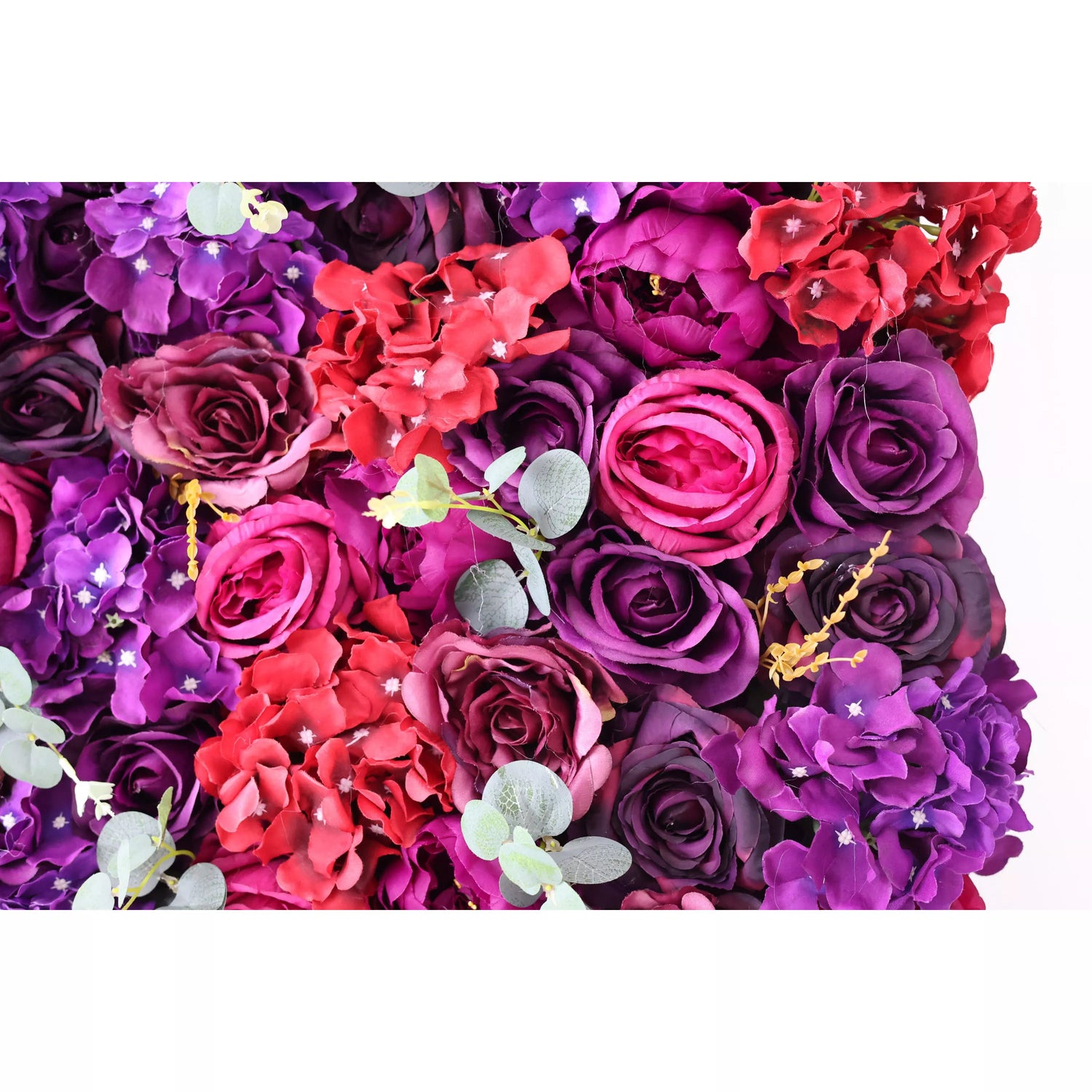 This close - up showcases a lush artificial flower wall, a rich blend of deep purple, magenta, and red blooms. Among them are roses, hydrangeas, and eucalyptus leaves, creating a textured, vibrant tapestry. The dense arrangement and contrasting colors make it an eye - catching backdrop, perfect for events like weddings or parties, adding an elegant and dramatic touch to the space.