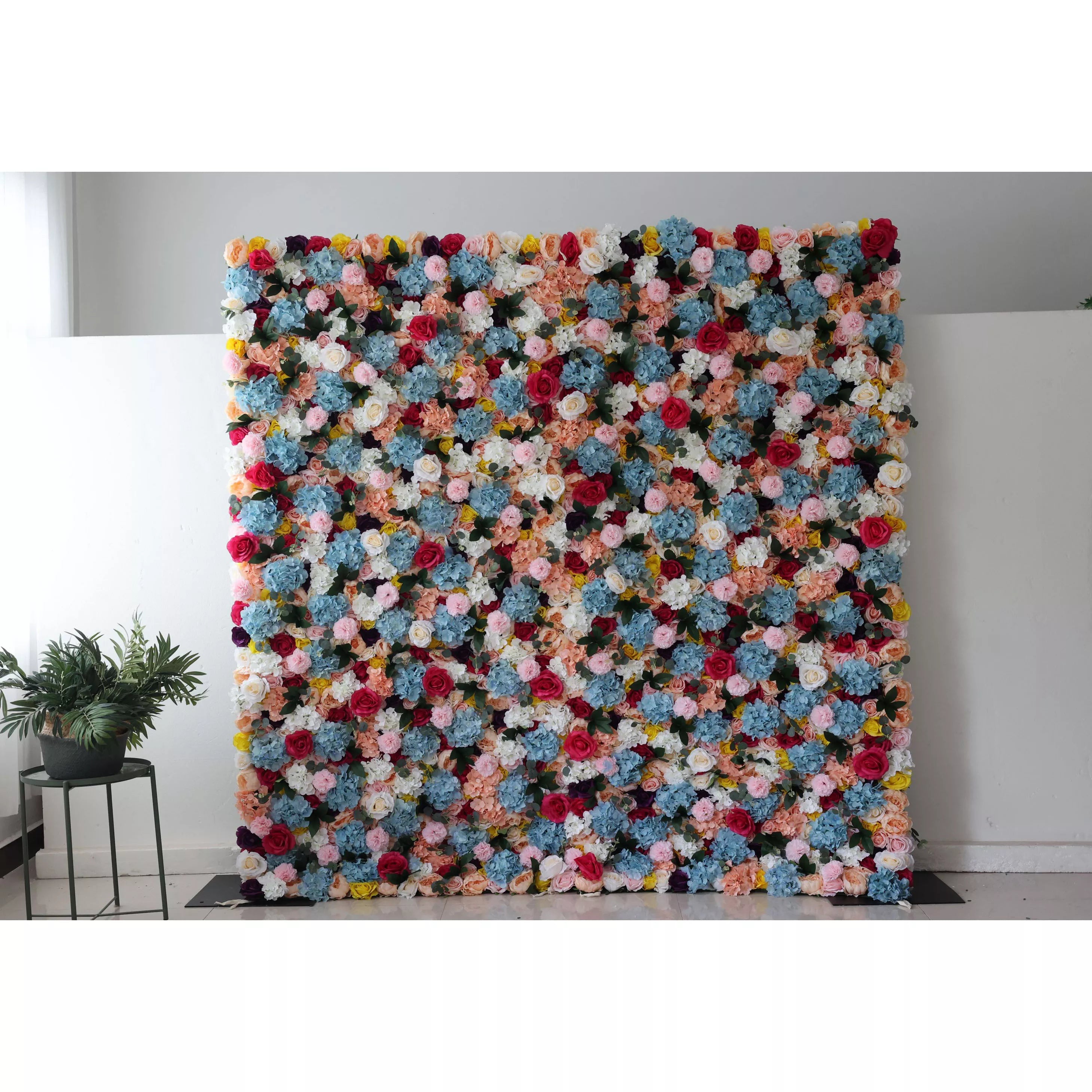 This is a large, vibrant artificial flower wall. It features a dense mix of colors—blue, pink, white, yellow, and red blooms. The varied flowers create a lively, eye - catching display, perfect for event backdrops, adding a cheerful and decorative touch to spaces.