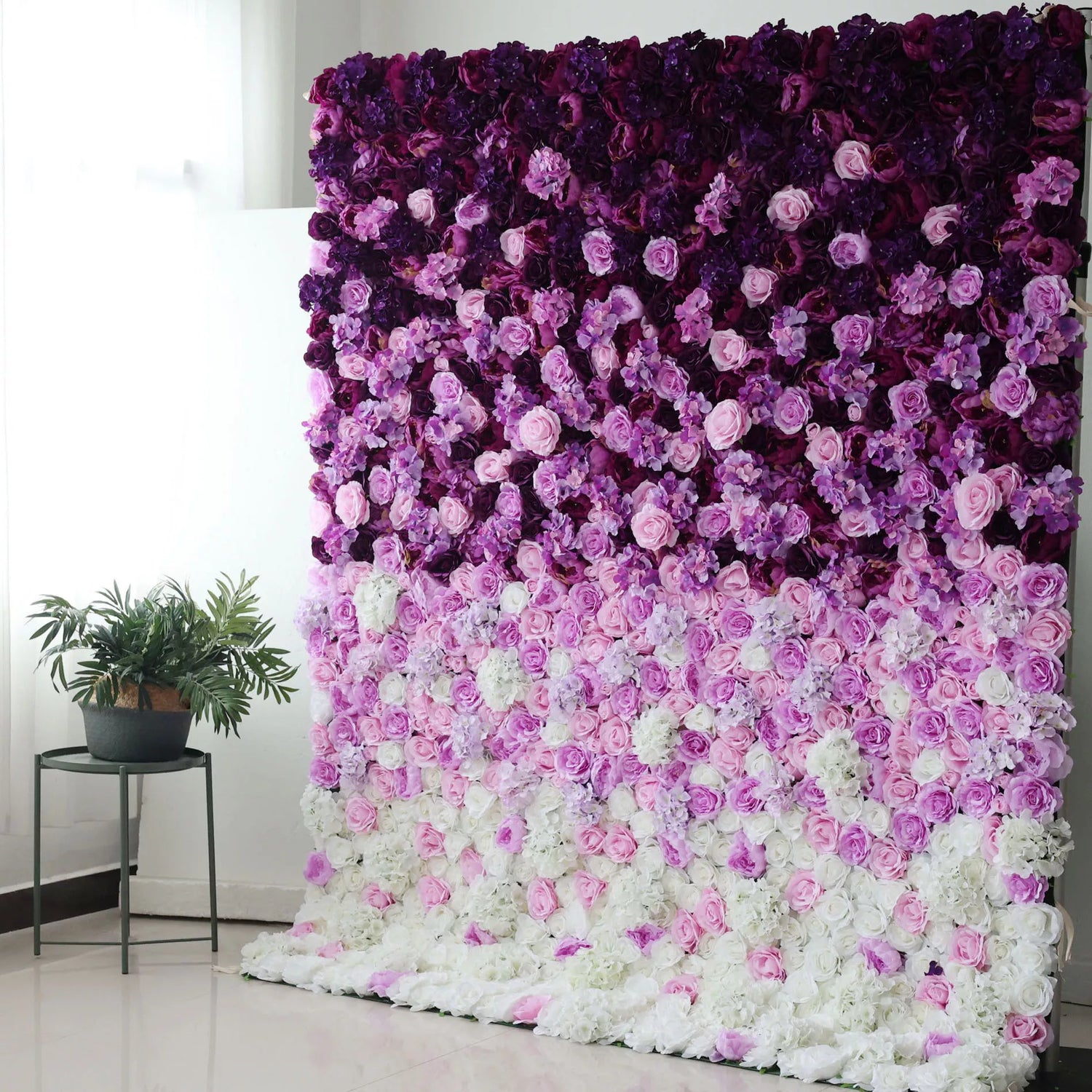 This flower wall is a captivating piece, densely adorned with artificial flowers. It showcases a gradient color scheme, transitioning from deep purple at the top, through lighter shades of lavender and pink, down to white at the bottom. Comprising roses and other delicate blooms, it creates a lush, romantic atmosphere, perfect as a backdrop for weddings, photo - shoots, or events, exuding an air of elegance and charm.
