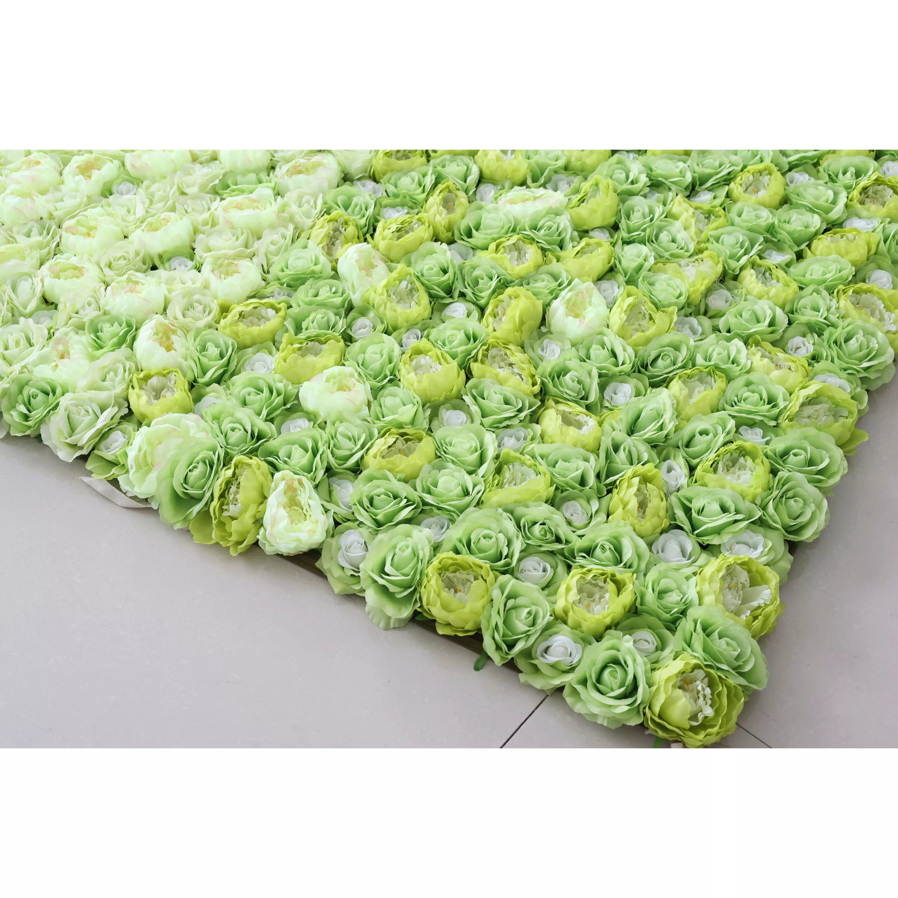 This flower wall features a dense arrangement of artificial roses in various shades of green and white. The lush, textured blooms create a fresh and vibrant look, perfect for decorative backdrops at events like weddings or parties. The gradient of colors adds visual interest, exuding a natural and elegant charm.