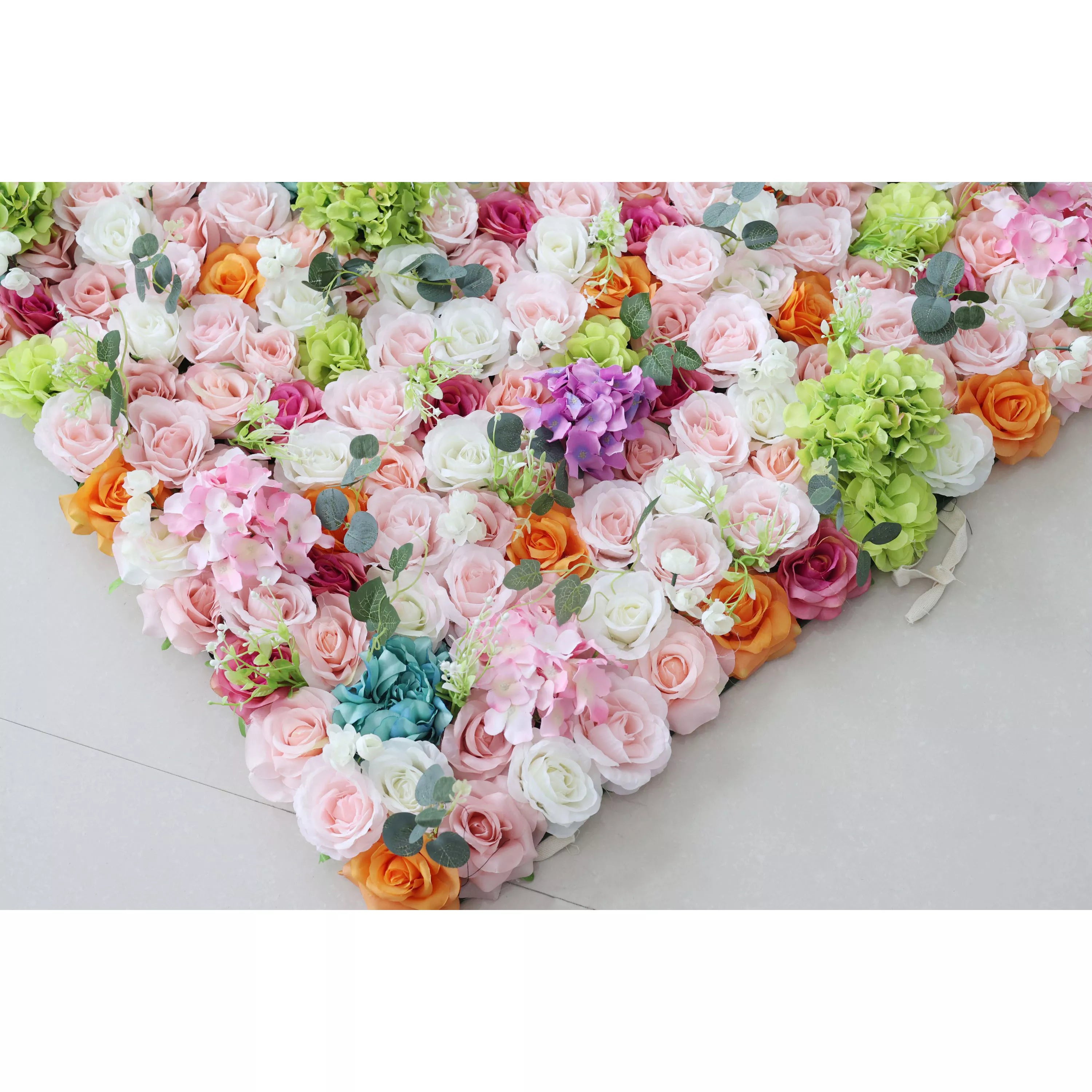 This is a heart - shaped artificial flower arrangement. It features a mix of roses in colors like pink, white, orange, purple, and blue, along with hydrangeas and eucalyptus - like leaves. Ideal for decorative purposes at events such as weddings or celebrations, creating a romantic and colorful ambiance.