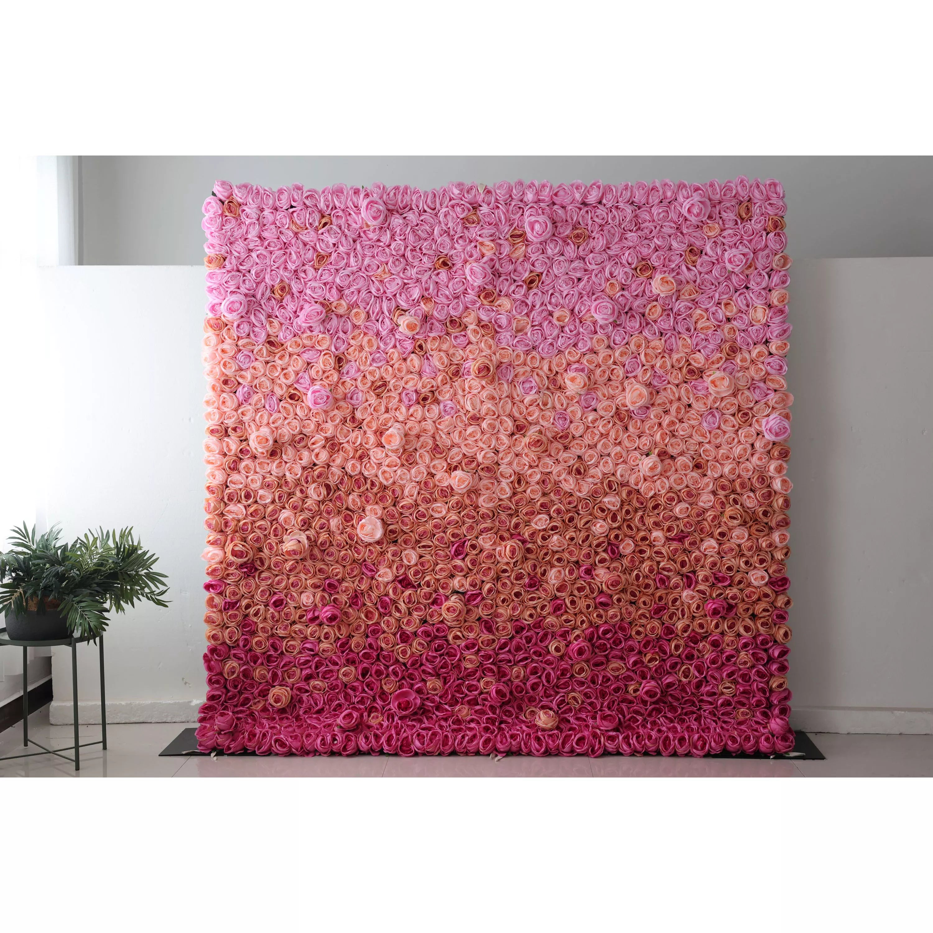 This picture showcases a large artificial flower wall, a beautiful gradient of pink shades. It&