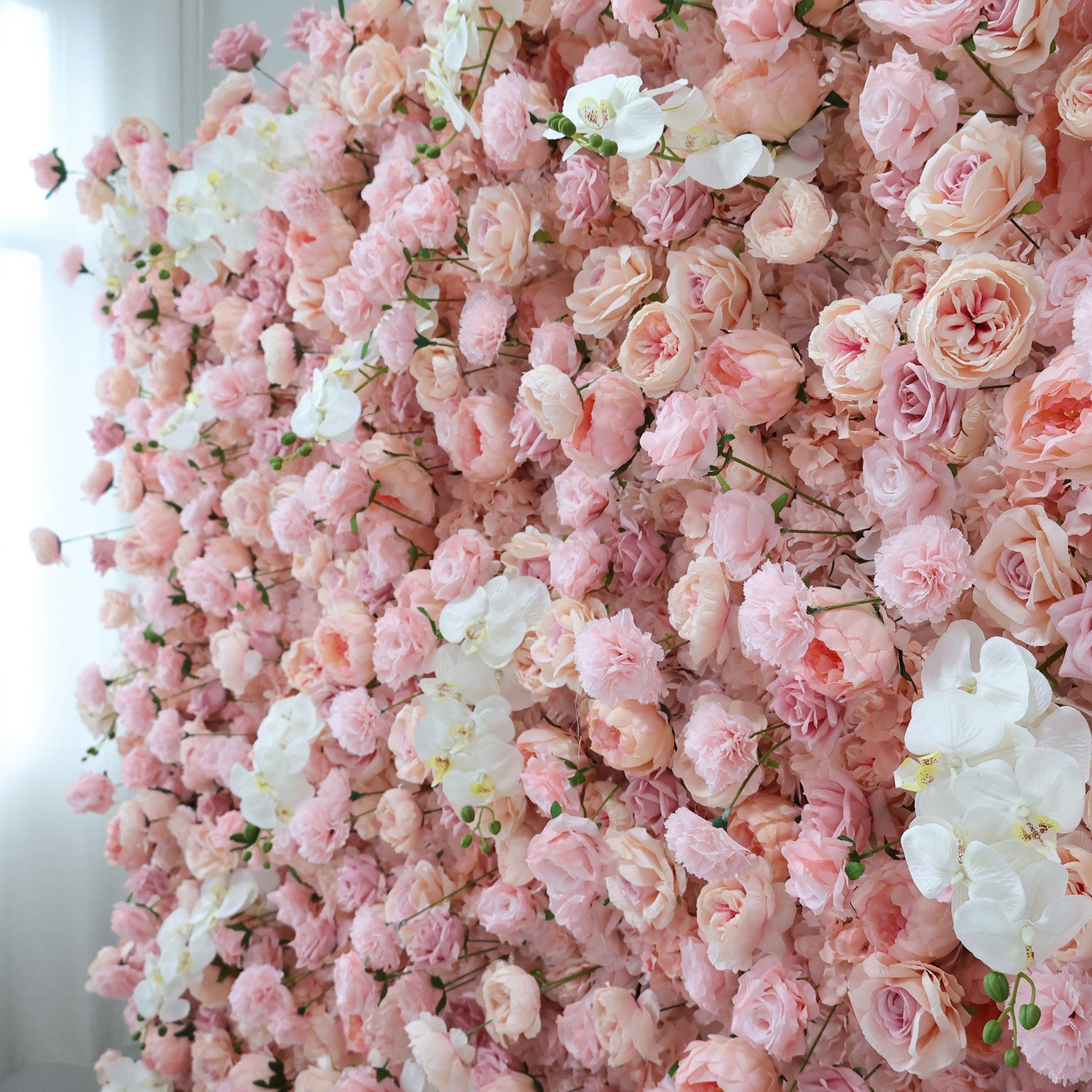 This image showcases a beautiful floral arrangement by Valar Flowers. It features a dense cluster of artificial flowers in soft, romantic shades of pink and white. The blooms, including roses and other complementary flowers, are intricately arranged to create a lush, textured, and visually appealing display. Perfect for adding a touch of elegance and charm to events or spaces, the arrangement exudes a delicate and sophisticated atmosphere.