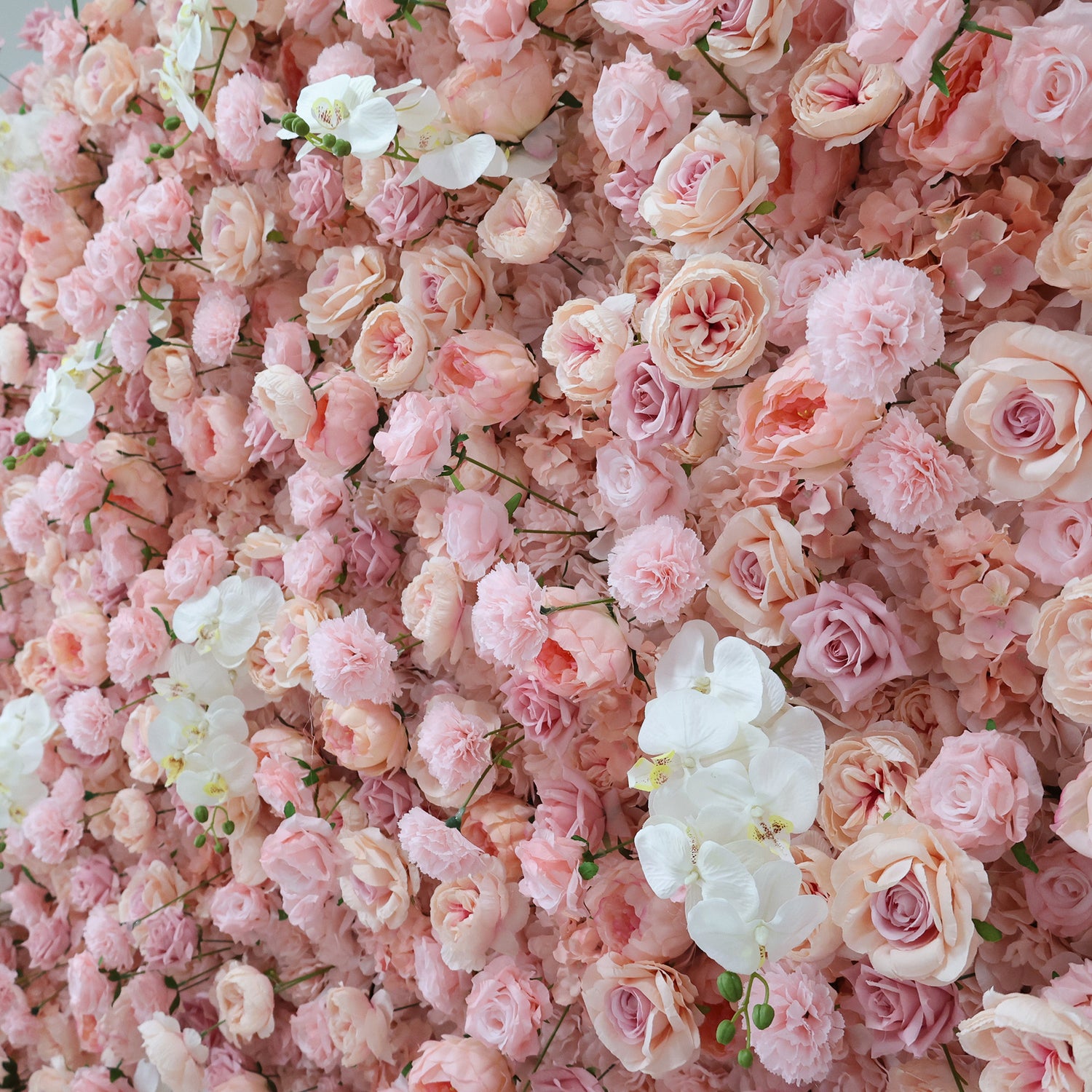 This image showcases a beautiful floral arrangement by Valar Flowers. It features a dense cluster of artificial flowers in soft, romantic shades of pink and white. The blooms, including roses and other complementary flowers, are intricately arranged to create a lush, textured, and visually appealing display. Perfect for adding a touch of elegance and charm to events or spaces, the arrangement exudes a delicate and sophisticated atmosphere.