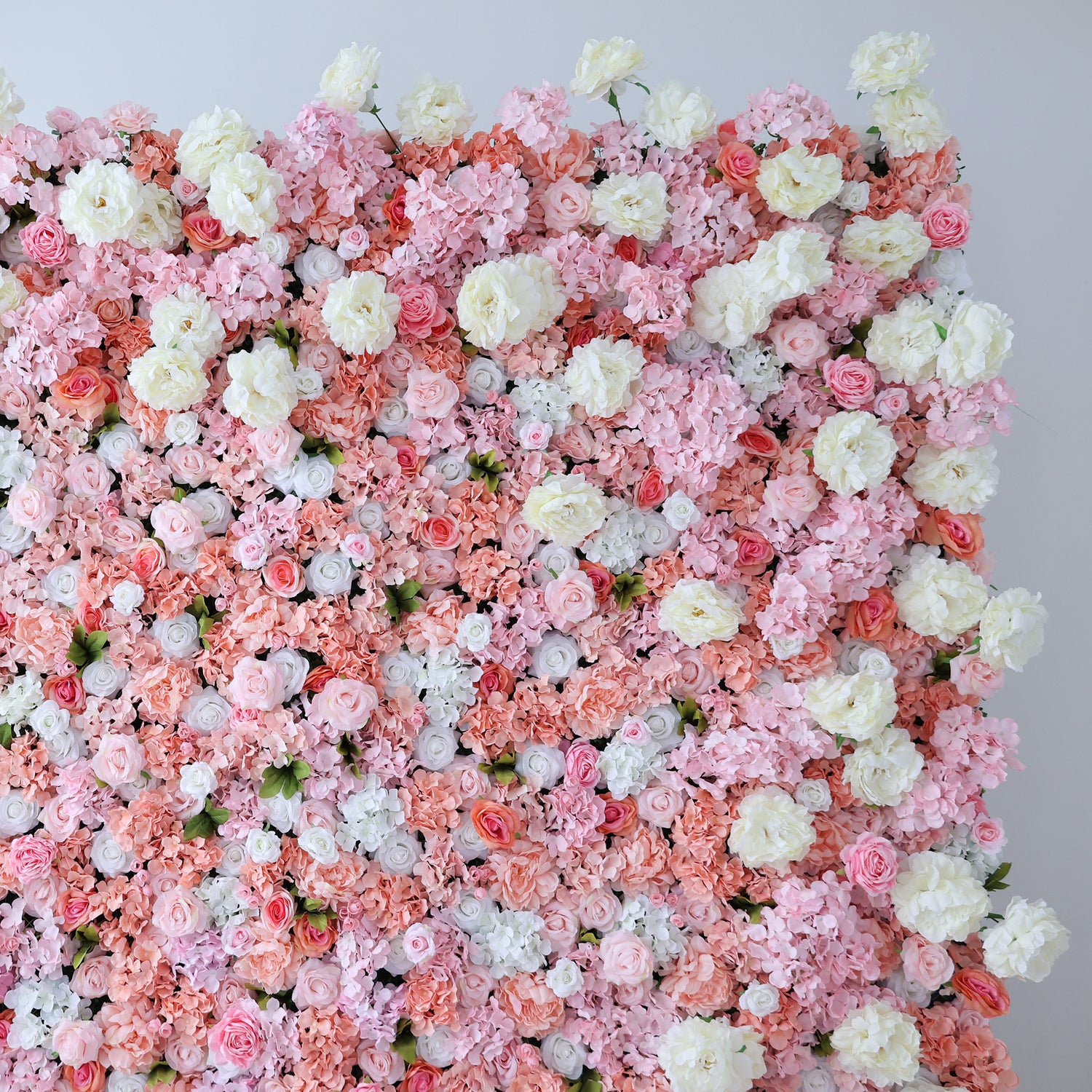 This image showcases a lush floral backdrop by ValarFlowers, featuring a dense arrangement of artificial flowers in shades of pink, peach, and white. The textured display exudes elegance, perfect for adding a luxurious, nature-inspired element to events or interiors, highlighting the brand’s expertise in crafting vibrant, sophisticated decor.