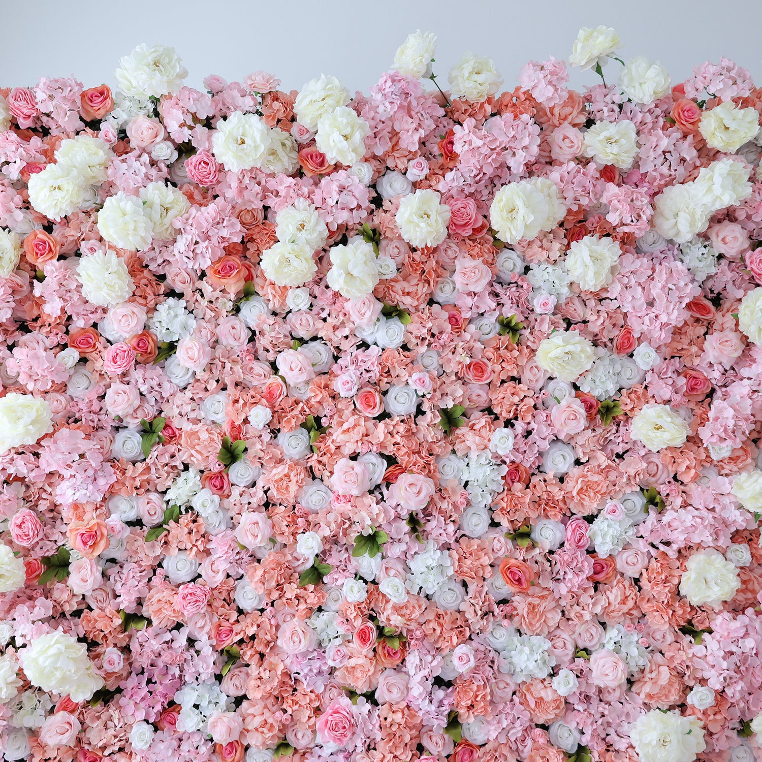 This image showcases a lush floral backdrop by ValarFlowers, with a dense arrangement of artificial flowers in shades of pink, peach, and white. The textured display exudes elegance, perfect for adding a luxurious, nature-inspired element to events or interiors, highlighting the brand’s craftsmanship in creating vibrant, sophisticated decor.