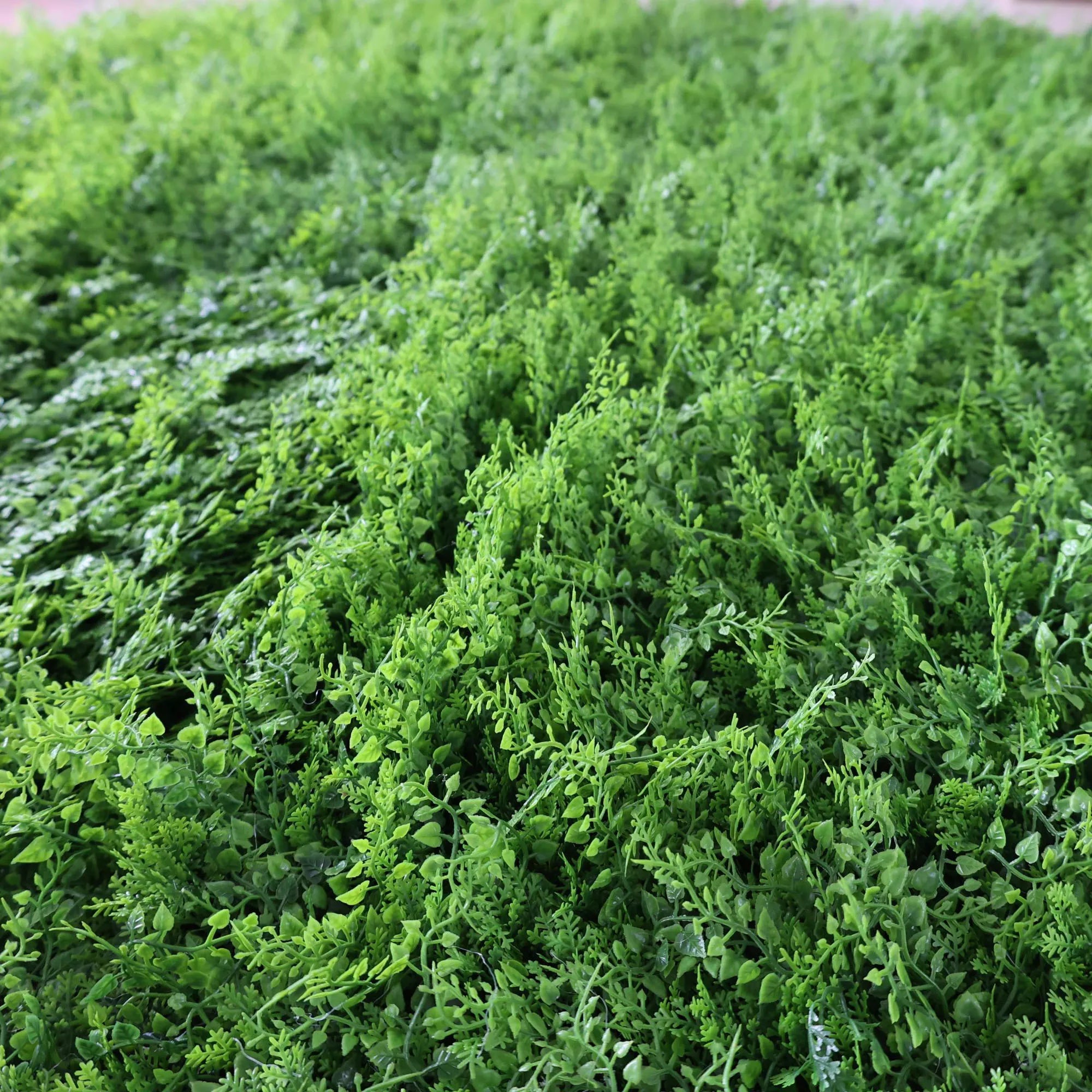 This image showcases a dense artificial greenery product by ValarFlowers. It features a variety of textured green foliage, creating a rich, natural, and visually refreshing display. The lush, varied leaves and stems mimic the look of real greenery, making it perfect for adding a touch of organic elegance to events or spaces. This piece exudes a serene and sophisticated atmosphere, characteristic of ValarFlowers’ attention to detail and craftsmanship.