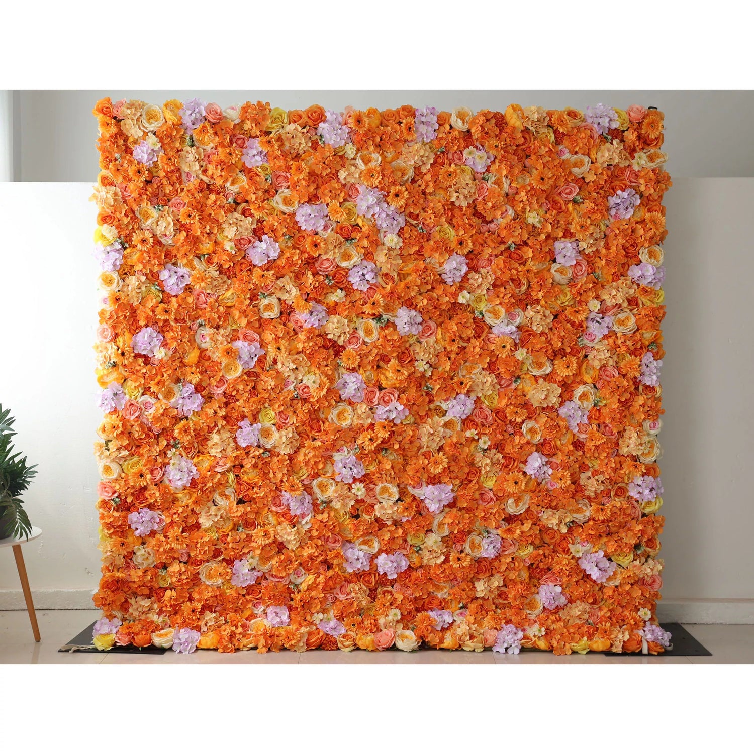 This image showcases a vibrant floral wall by Valar Flowers, set indoors. It&