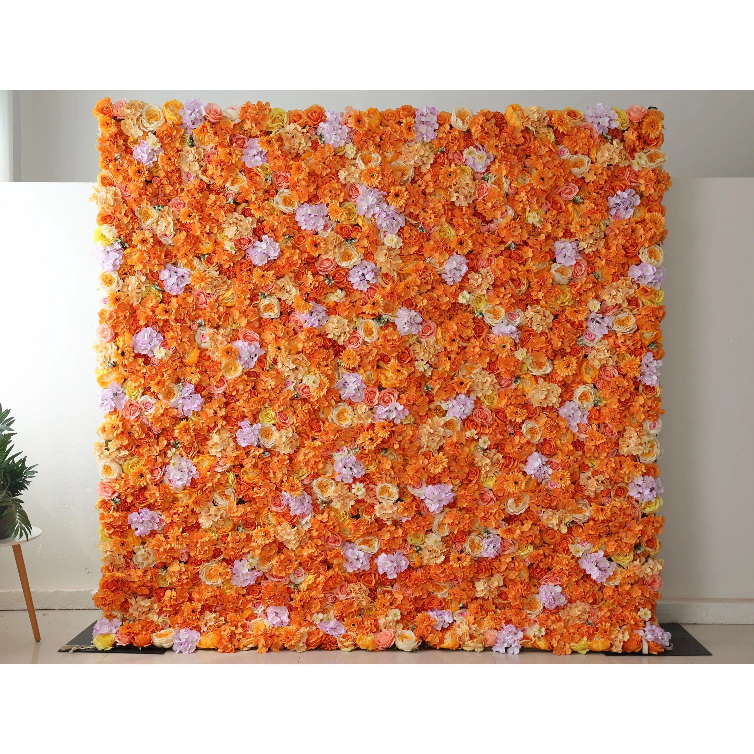 This image showcases a vibrant floral wall by Valar Flowers, set indoors. It&