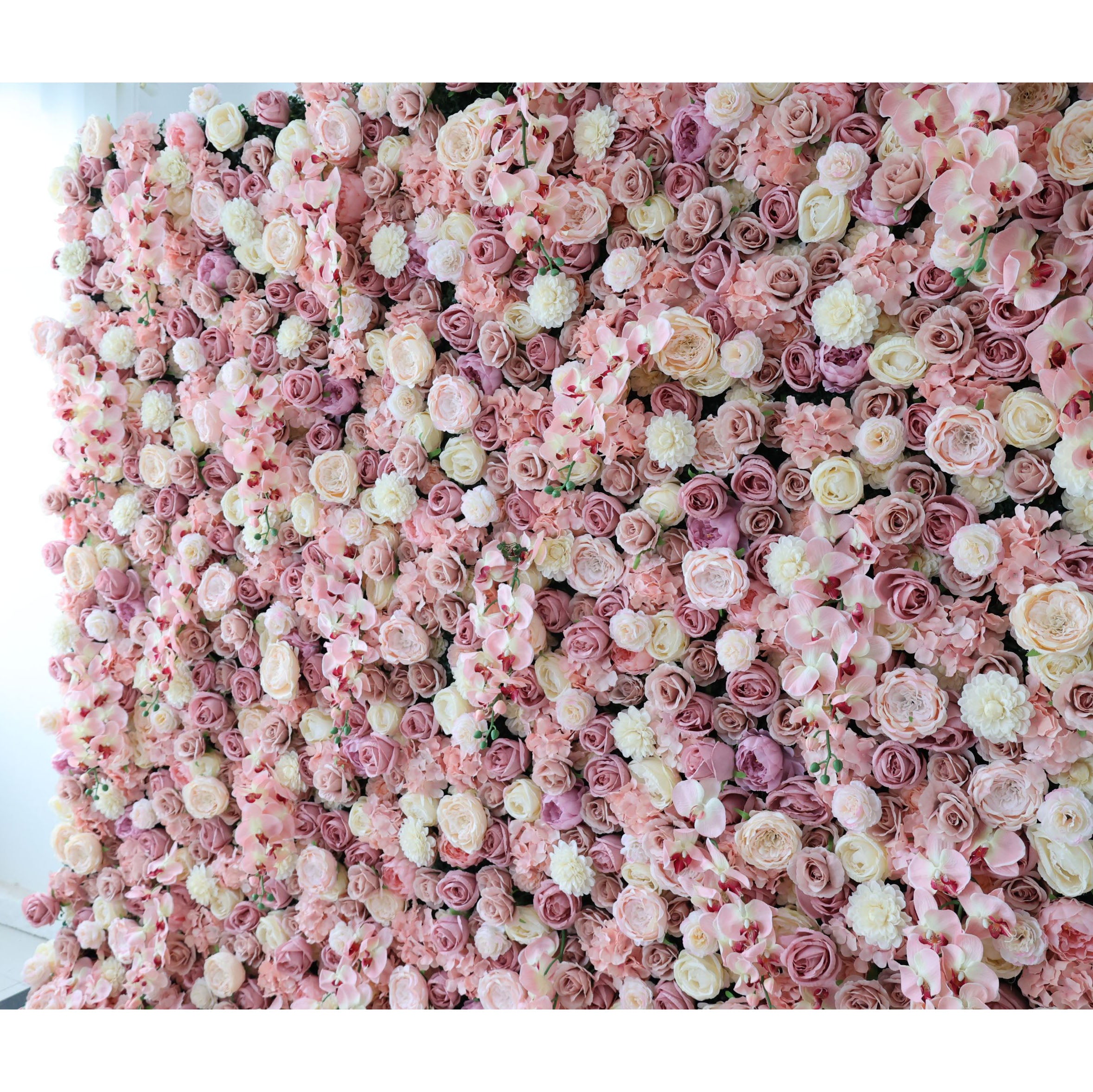 This is a close-up of a premium blush pink artificial flower wall by Valar Flowers, featuring a lush, dense arrangement of lifelike roses, orchids, and carnations in soft pink, champagne, and ivory tones. High-quality, hyper-realistic petals with natural texture deliver an elegant, romantic, maintenance-free aesthetic, perfect for wedding backdrops, photo booths, bridal showers, and luxury indoor/outdoor event styling.