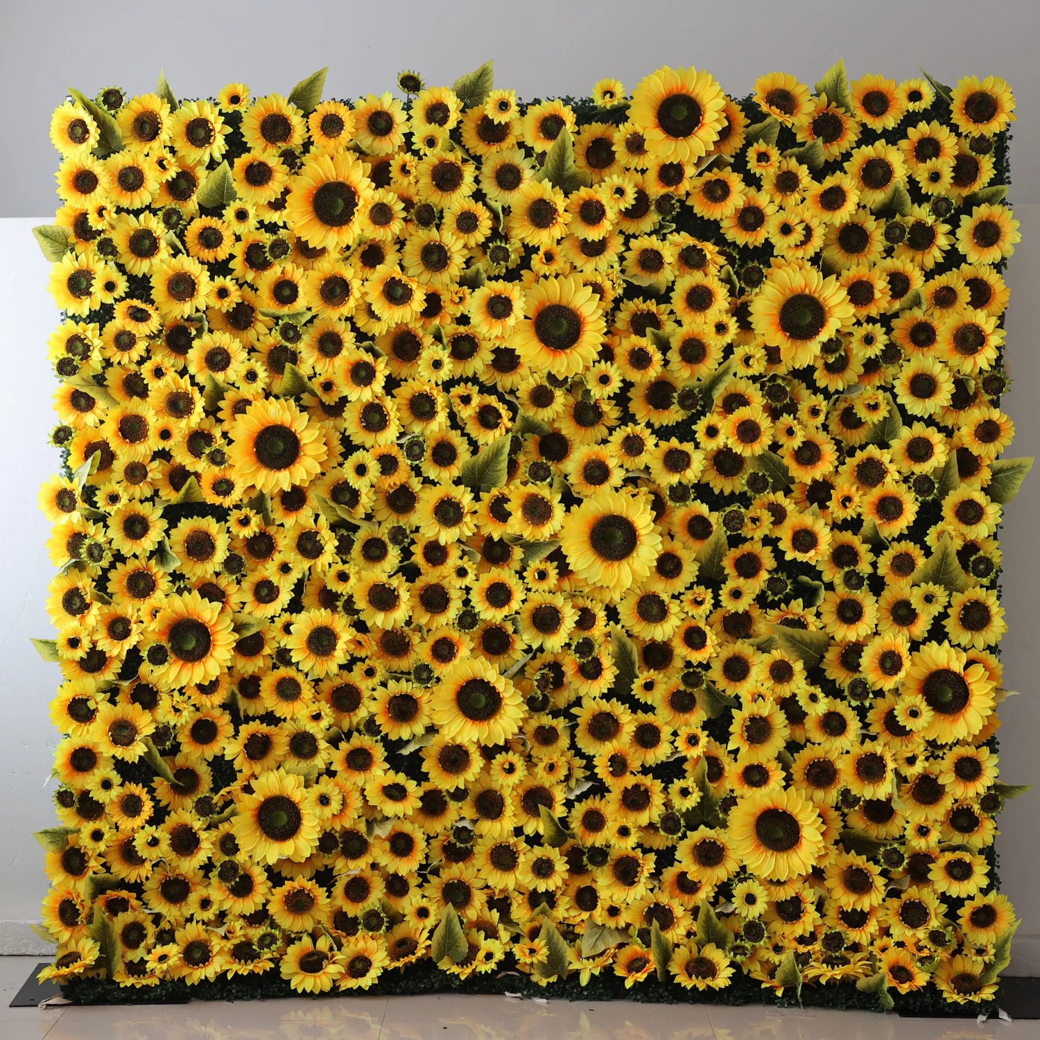This flower wall is a vibrant display of artificial sunflowers. Dense, bright yellow blooms with dark centers and green leaves create a cheerful, eye - catching backdrop. Ideal for events like weddings or photo booths, it brings a sunny, lively atmosphere with its abundant, realistic - looking floral arrangement.