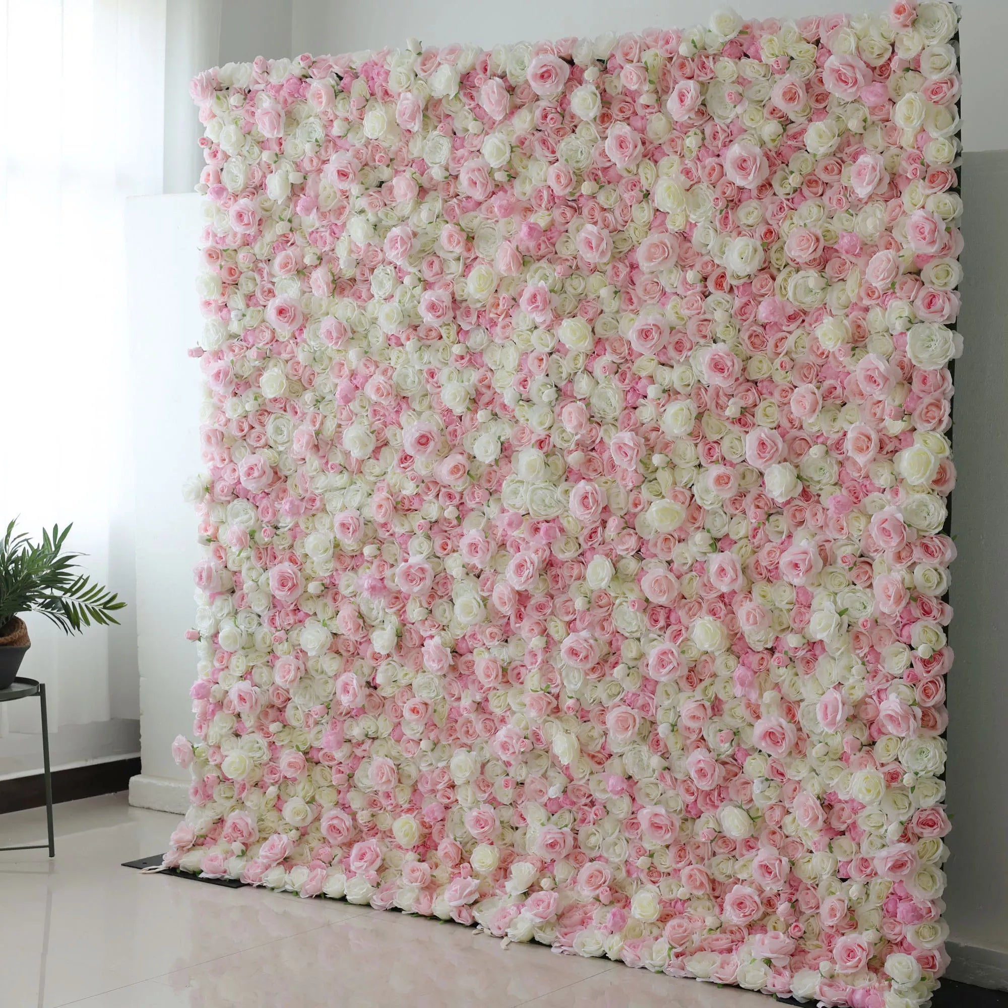This is a large, rectangular artificial flower wall backdrop, densely packed with a lush mix of soft pink, white, and pale green roses and peonies. It stands upright indoors on a shiny tiled floor, creating a romantic, elegant, and dreamy display perfect for weddings, photo shoots, or special events.