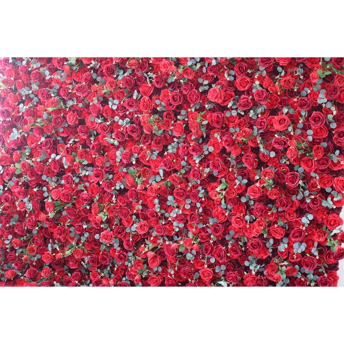 This flower wall is a stunning display of artificial red roses, densely packed with eucalyptus leaves adding a touch of green. The vibrant red blooms create a passionate, romantic texture, perfect for weddings or events. It exudes elegance and intensity, serving as a captivating backdrop for photos and decor.