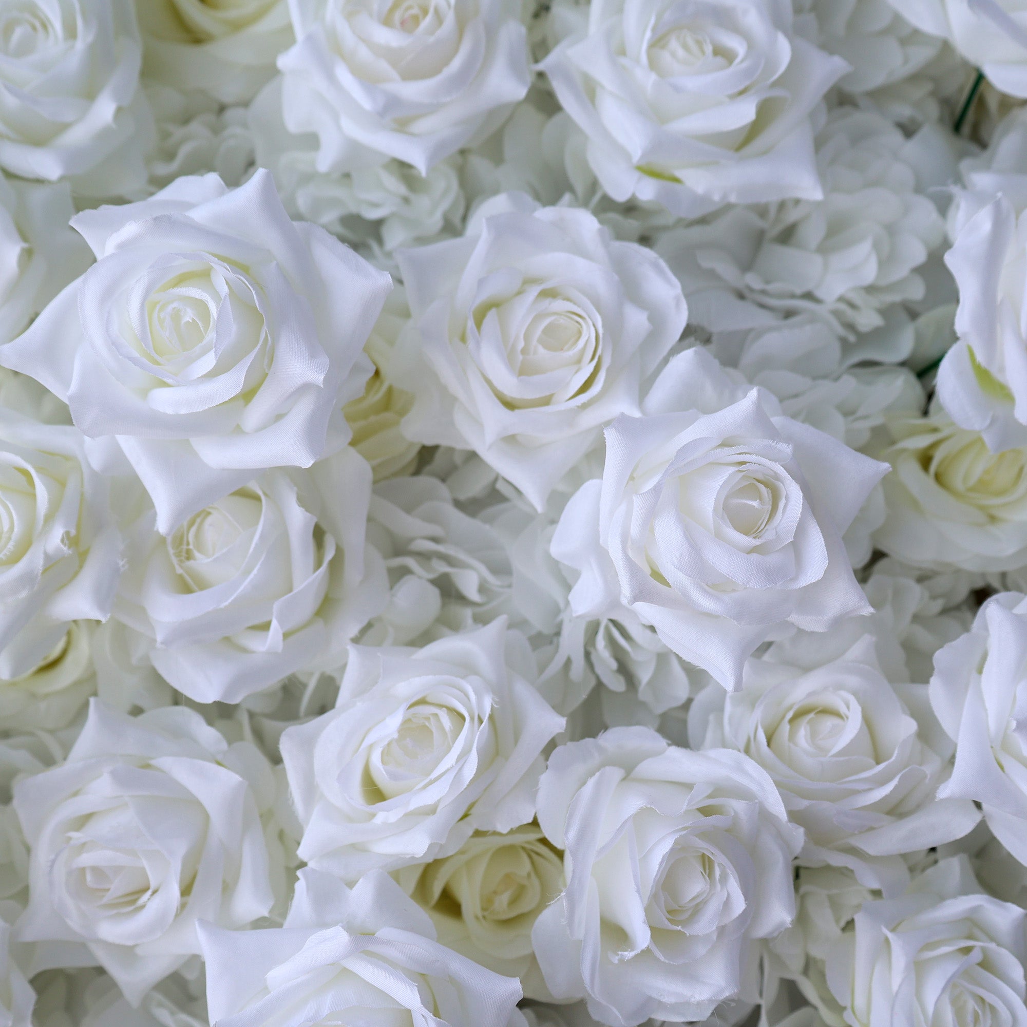 This photo showcases a lush arrangement of artificial white roses, likely from ValarFlowers. The blooms are densely packed, with petals crafted to mimic the delicate texture of real roses. The uniform white hue creates a serene, elegant aesthetic, perfect for weddings, events, or home decor. The realistic design offers long-lasting beauty, ideal for adding a touch of timeless sophistication to any setting.