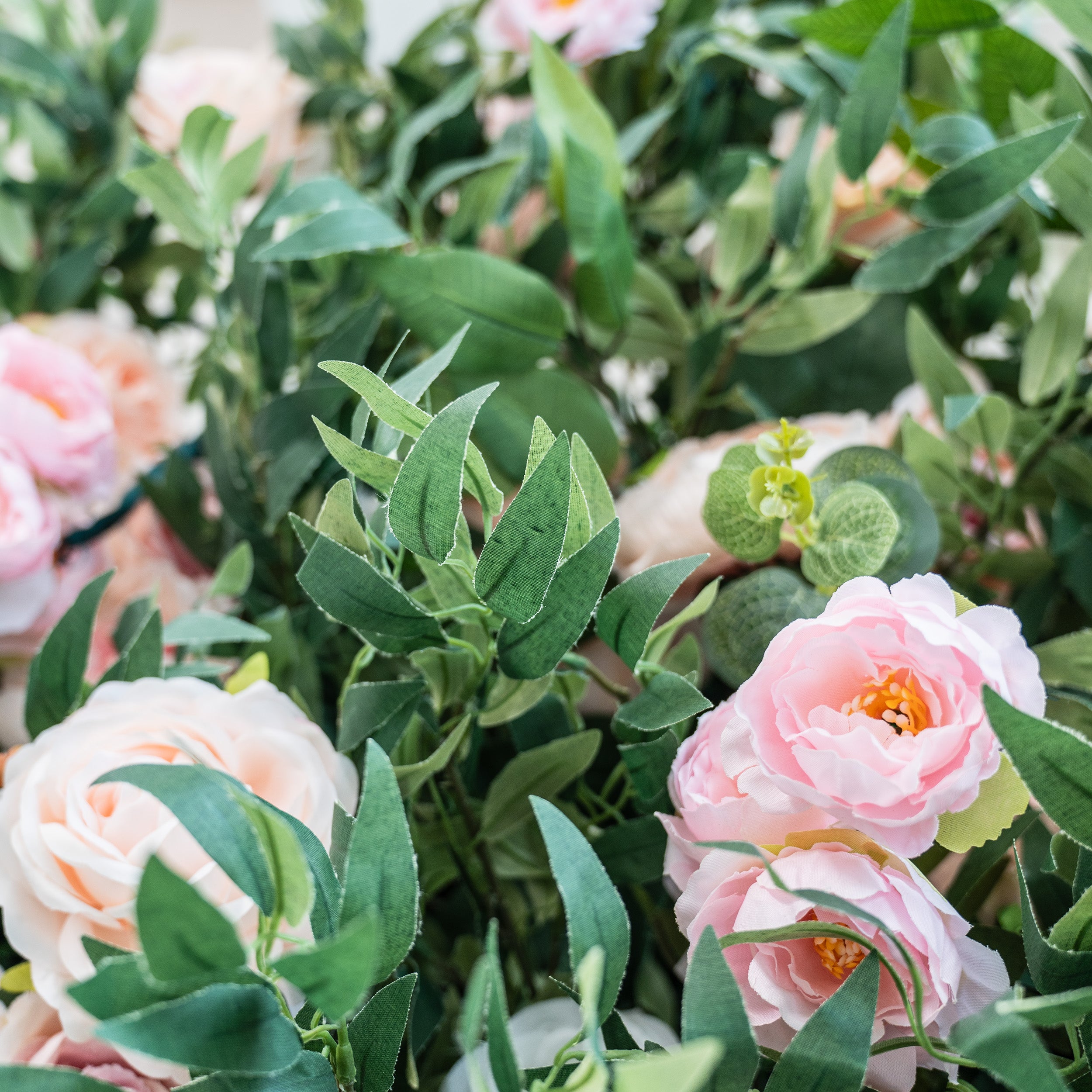 This photo showcases a lush arrangement of pink roses nestled among various green foliage. The soft hues of the roses and the rich greenery create a serene and elegant look. Ideal for events such as a "Mother&