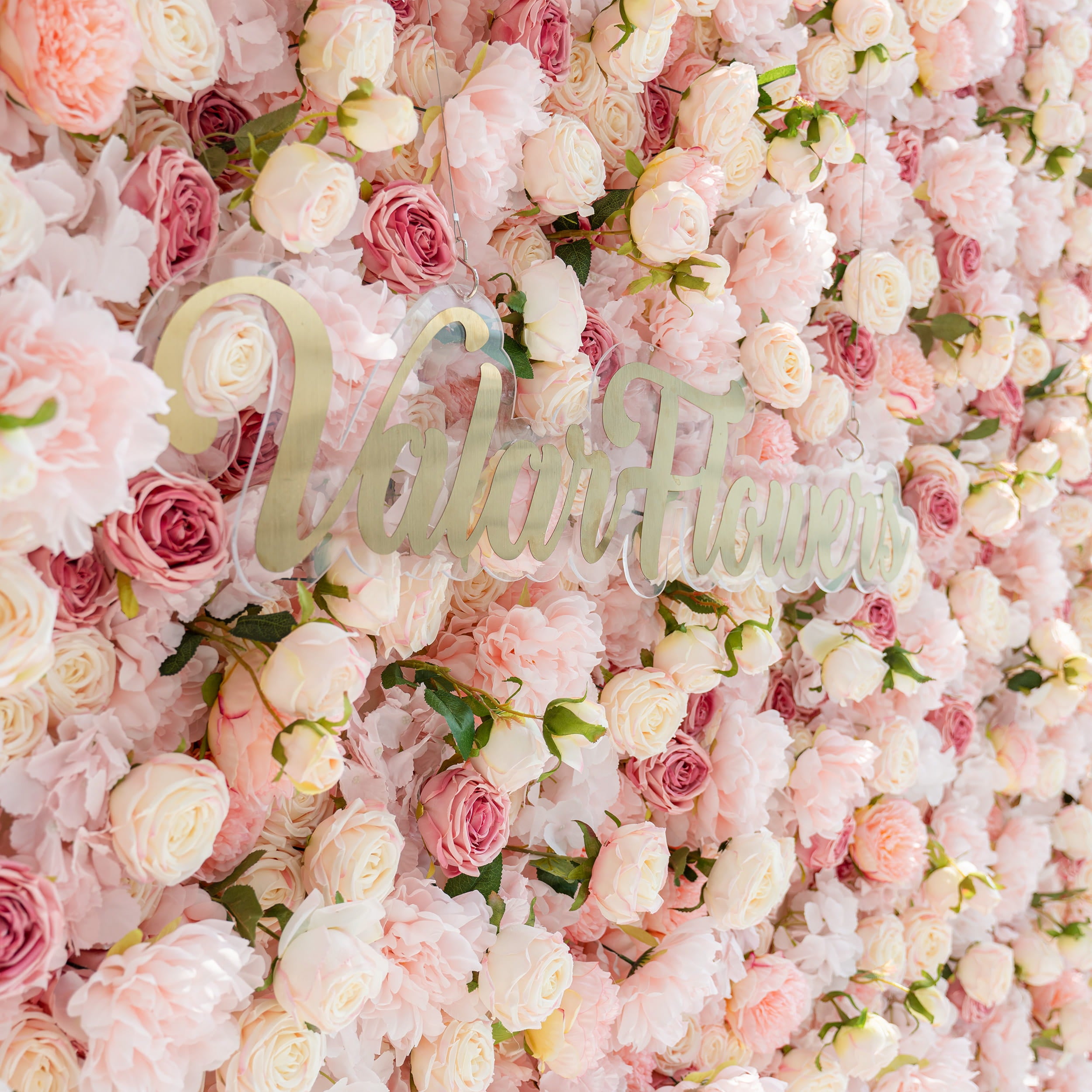 A stunning flower wall adorned with an array of pink and white roses. The text "Valar Flowers" is prominently displayed, adding a touch of elegance and branding to the beautiful floral backdrop.