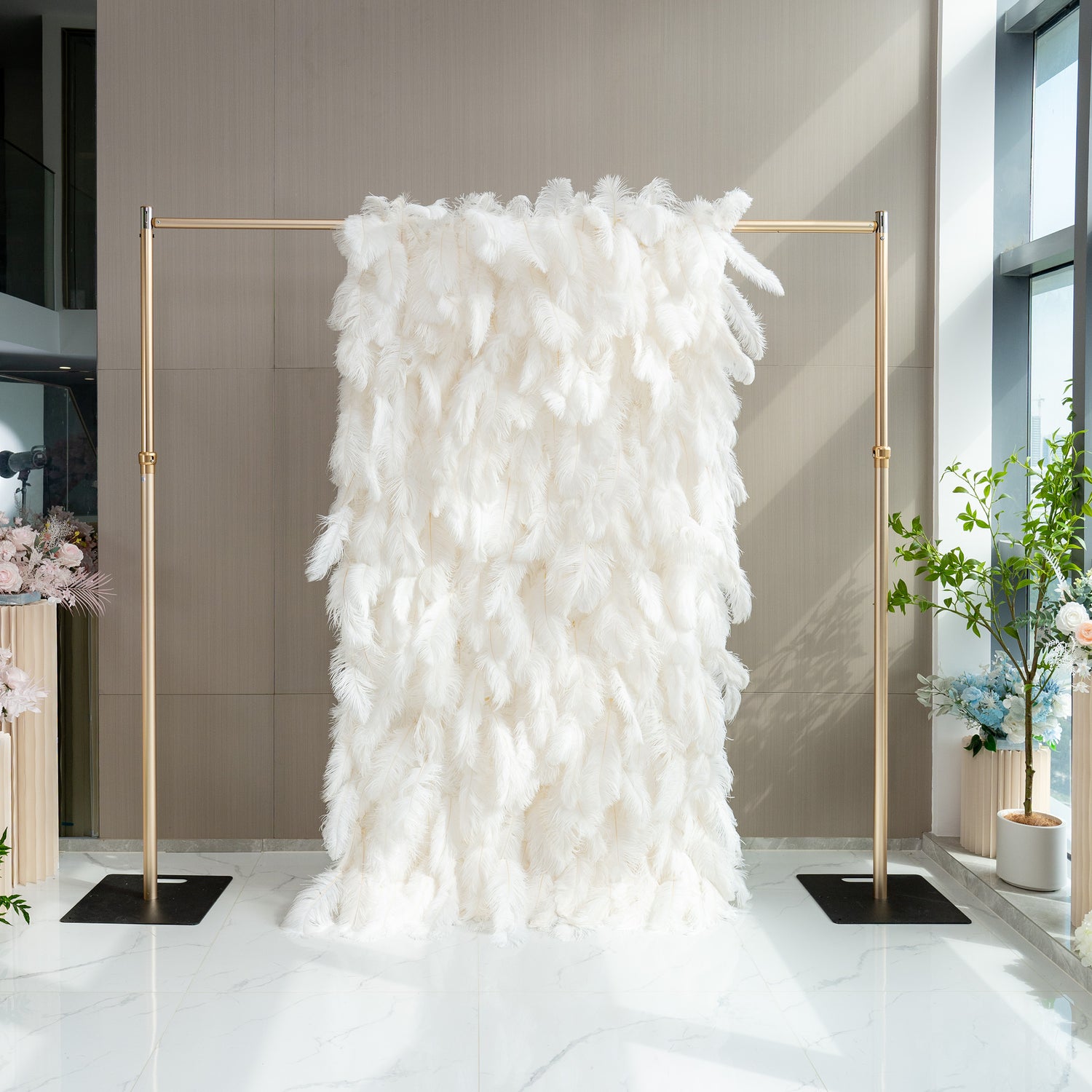 The ValarFlowers artificial feather wall is a luxurious display of white feathers. It has a soft, plush appearance, creating an elegant and dreamy backdrop, perfect for events.